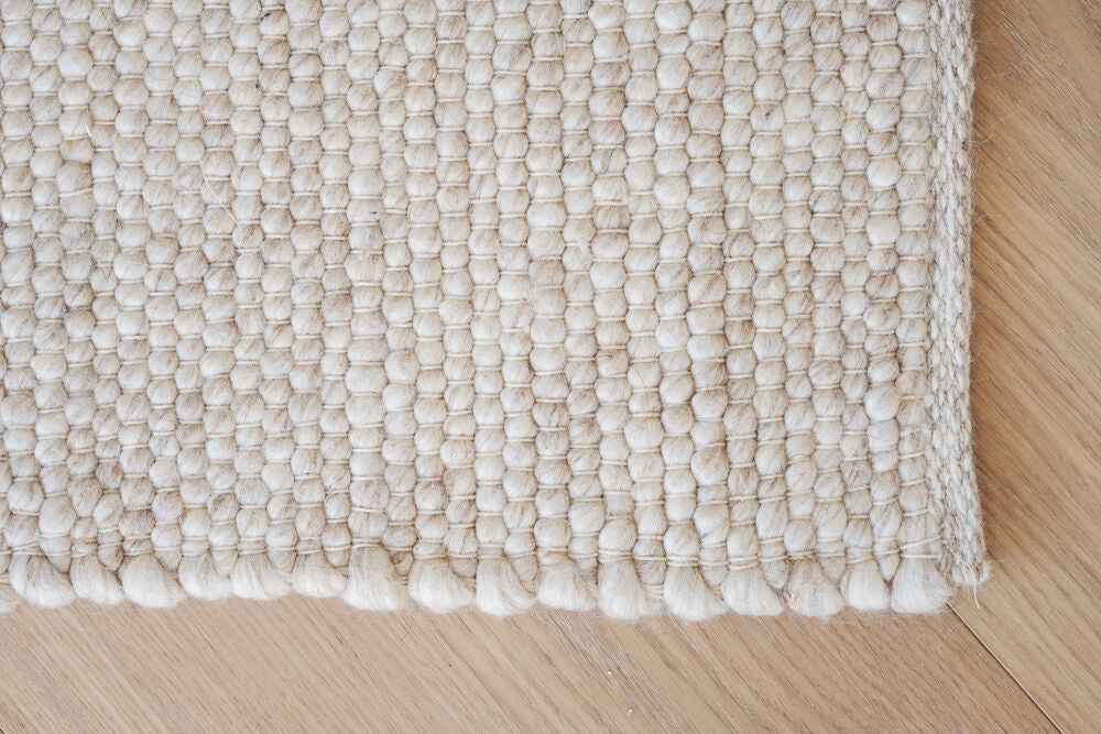 Auckland-villamatto. on 100 % villaa. Kuvassa on beige Auckland-villamatto.