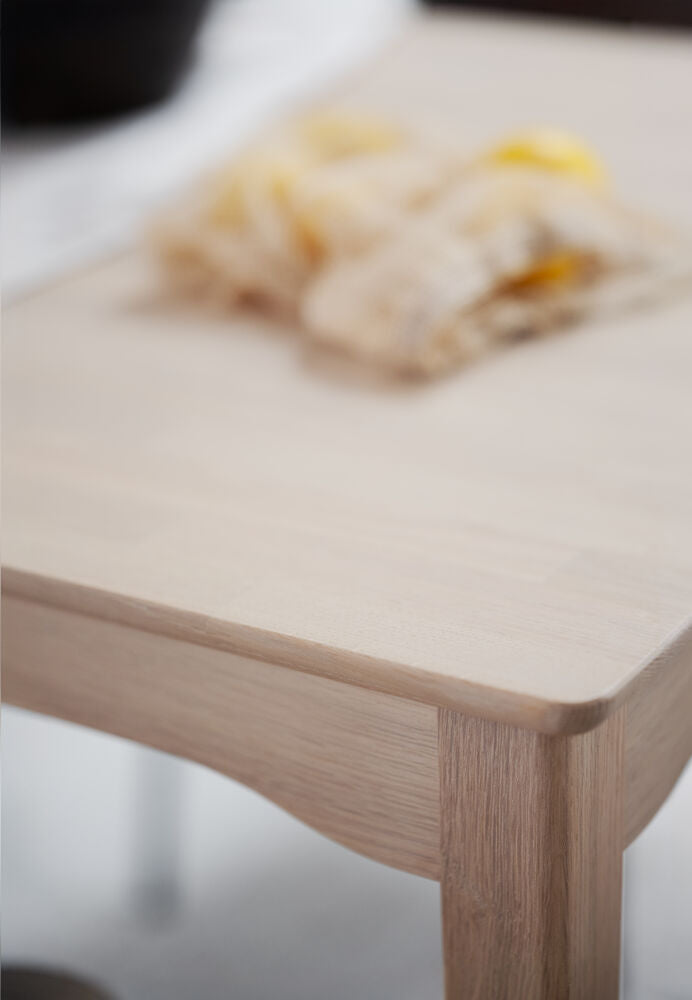 Lähikuvassa näkyy valkotammenvärisen Markham-ruokapöydän viimeisteltyjä yksityiskohtia.