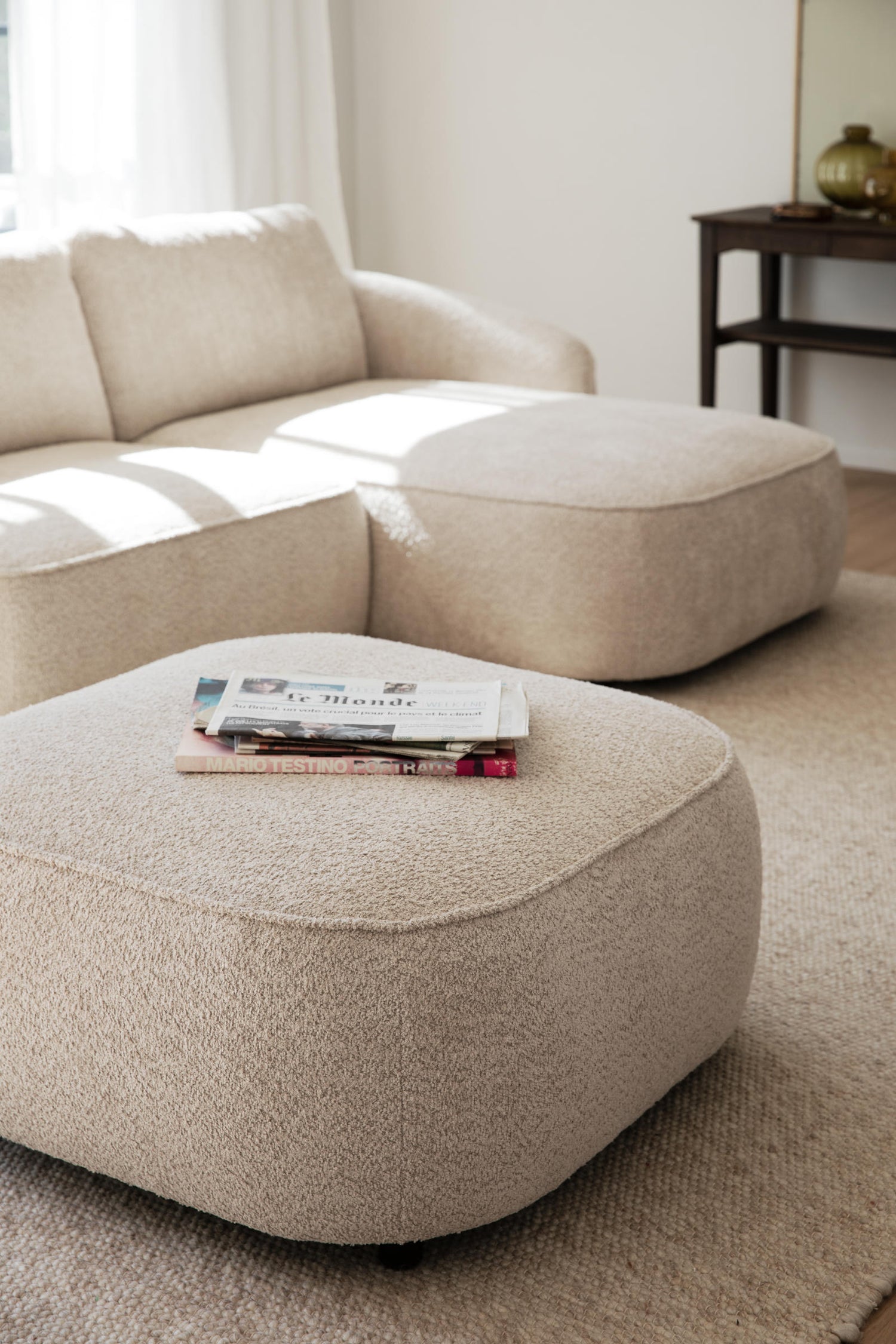 Kuvassa vaalean beige Norris-rahi verhoiltuna Chenillen kaltaisella Anna 2-kankaalla. Moduulisohvasarjassa on mustat 5 cm korkeat jalat. Taustalla Norris-divaanisohva, joka myydään erikseen.