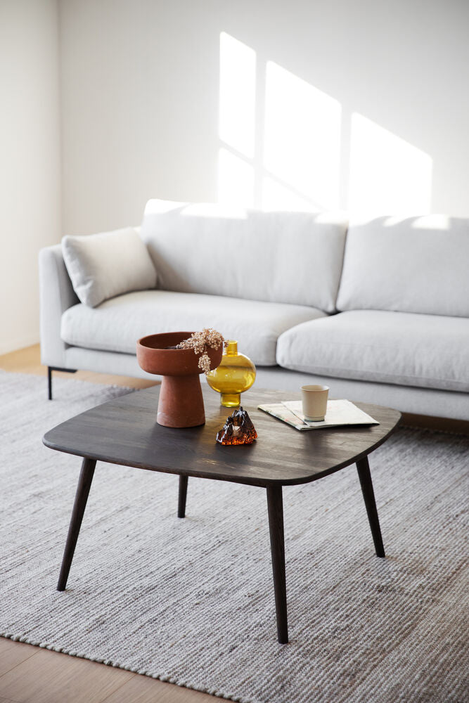 Kuvassa 3-istuttava Corwin-sohva vaalealla Rita 1-kankaalla verhoiltuna ja mustilla metallijaloilla. Sohvan edessä on Rowicon Tompkins-sohvapöytä.