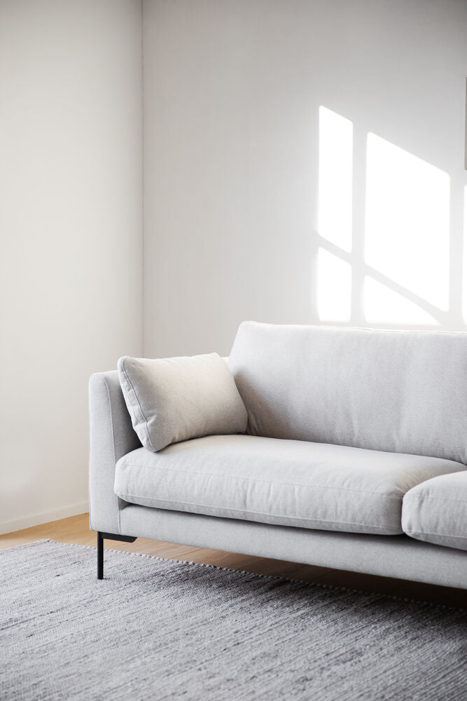 Kuvassa 3-istuttava Corwin-sohva vaalealla Rita 1-kankaalla verhoiltuna ja mustilla metallijaloilla.