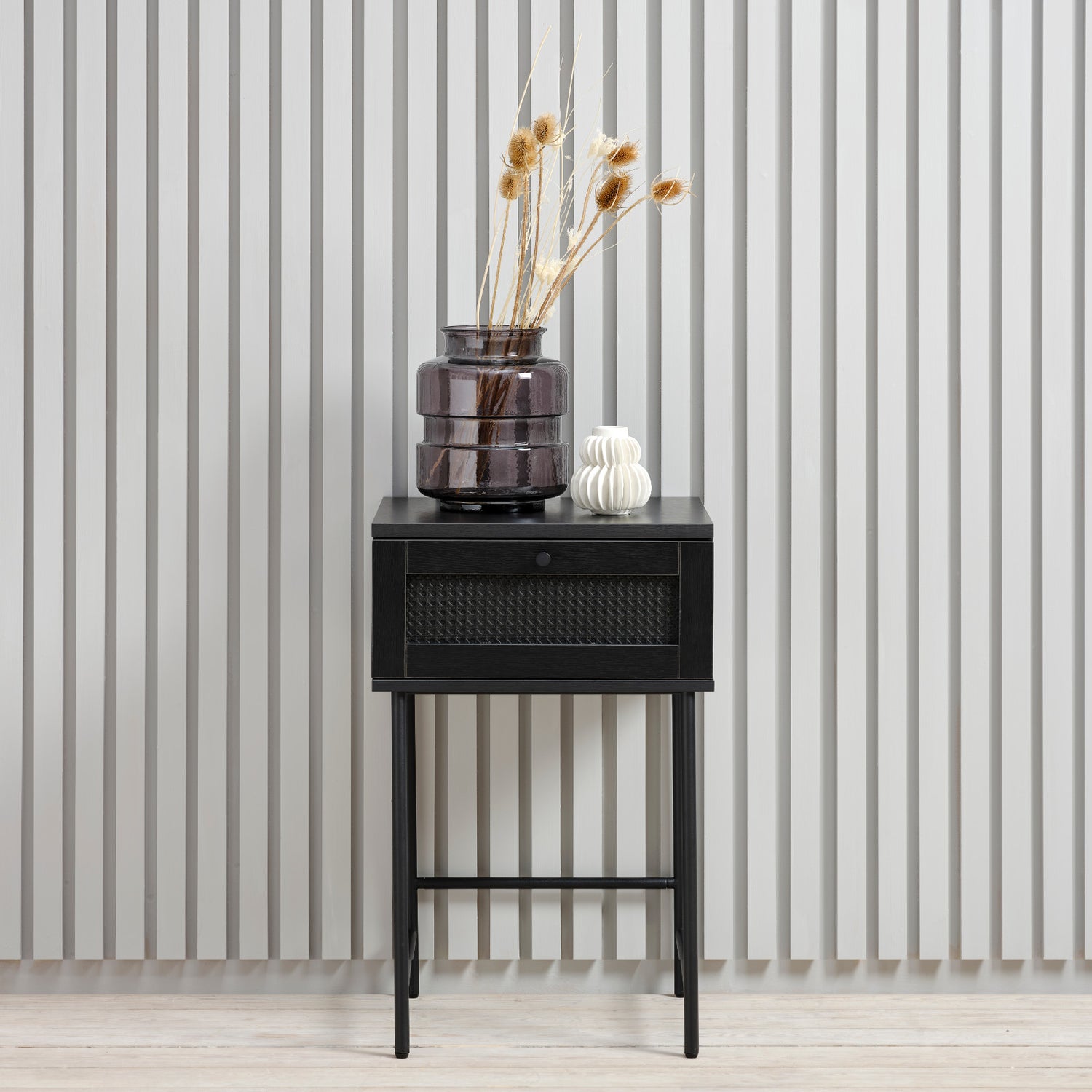 Kuvassa on Pensacola-yöpöytä/sivutaso musta. Pensacola-yöpöytä/sivutaso musta. Pikkutason laatikon
etulevyssä on yksityiskohtana polyrottinki. Mustat metallijalat.