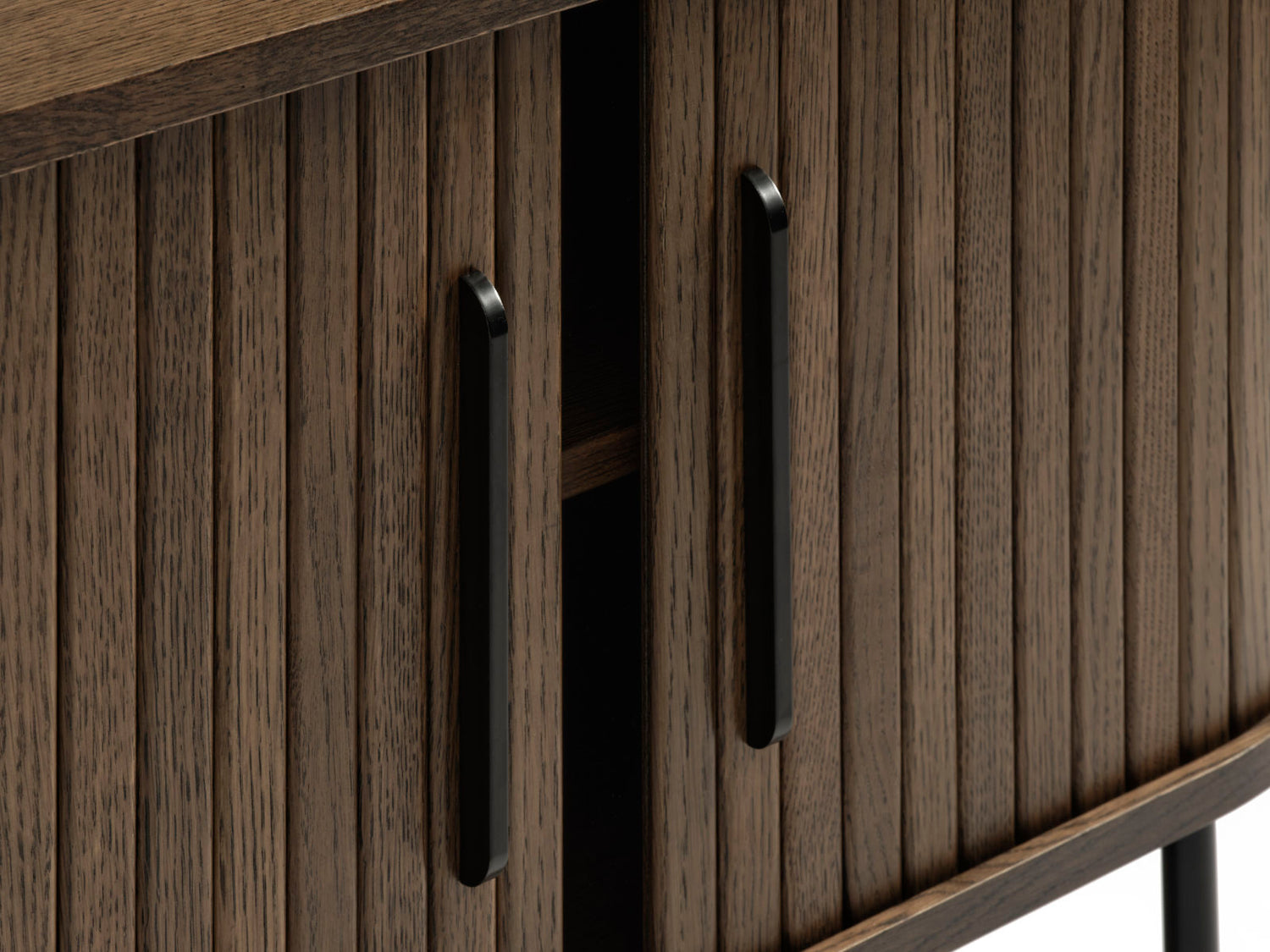 Ovaalinmuotoinen Nola-tv-taso 120 cm, savutammenvärinen. Tasossa on mustat metalliset vetimet liukuovissa ja mustat säädettävät metallijalat.