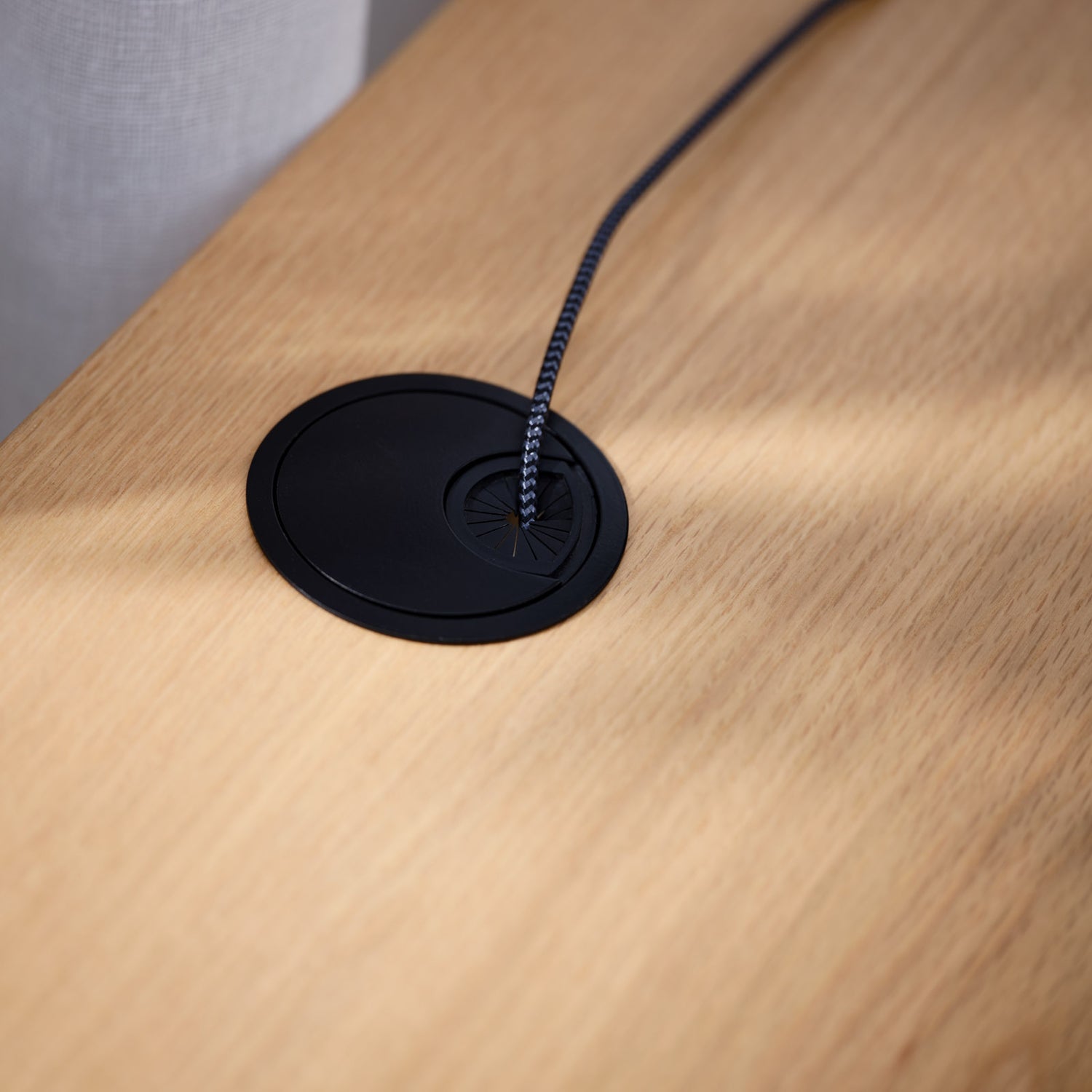 Lähikuvassa Nola-työpöydän kannen pintaa tammenvärisenä - kannessa on johtoaukko.