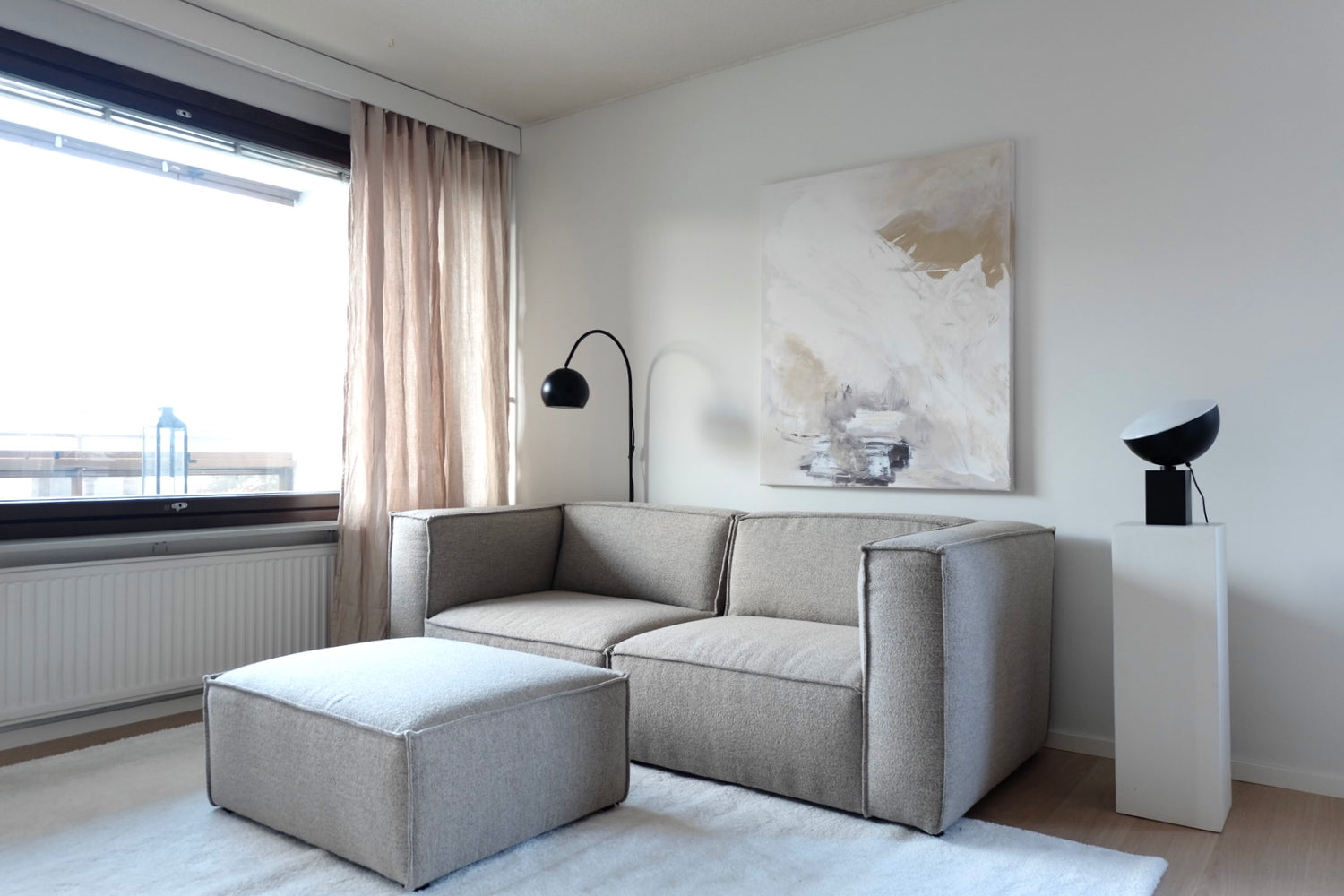 Kuvassa on 3-istuttava Beacon-sohva hiekanvärisellä Boucle Crush -kankaalla. Sohvan edessä on saman sarjan erikseen myytävä rahi.