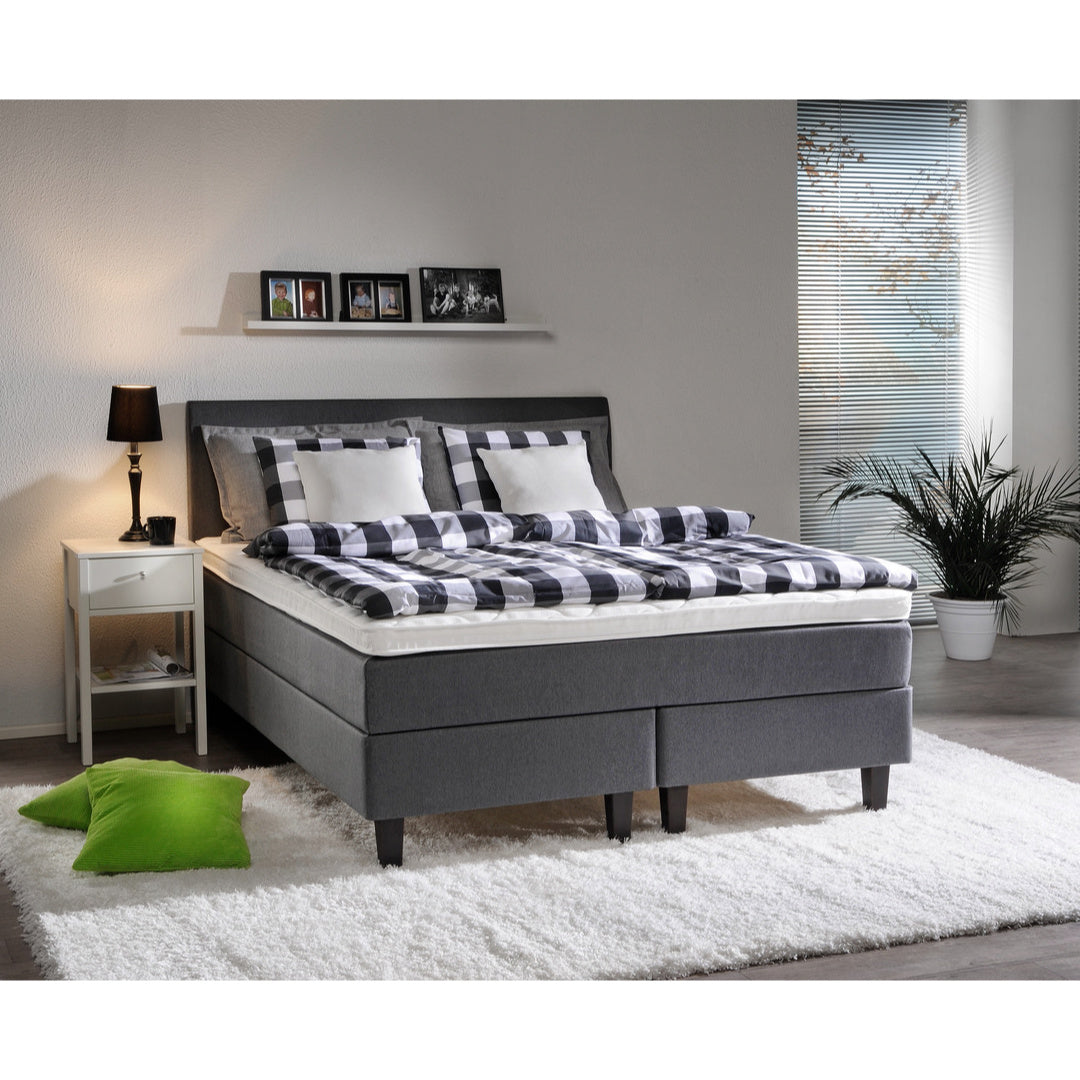 Harmaa Meri -jenkkisänky wengen värisillä Royal-jaloilla ja profiloidulla sijauspatjalla. Kuvan Aalto-sängynpääty ja kuvausrekvisiitta myydään erikseen.