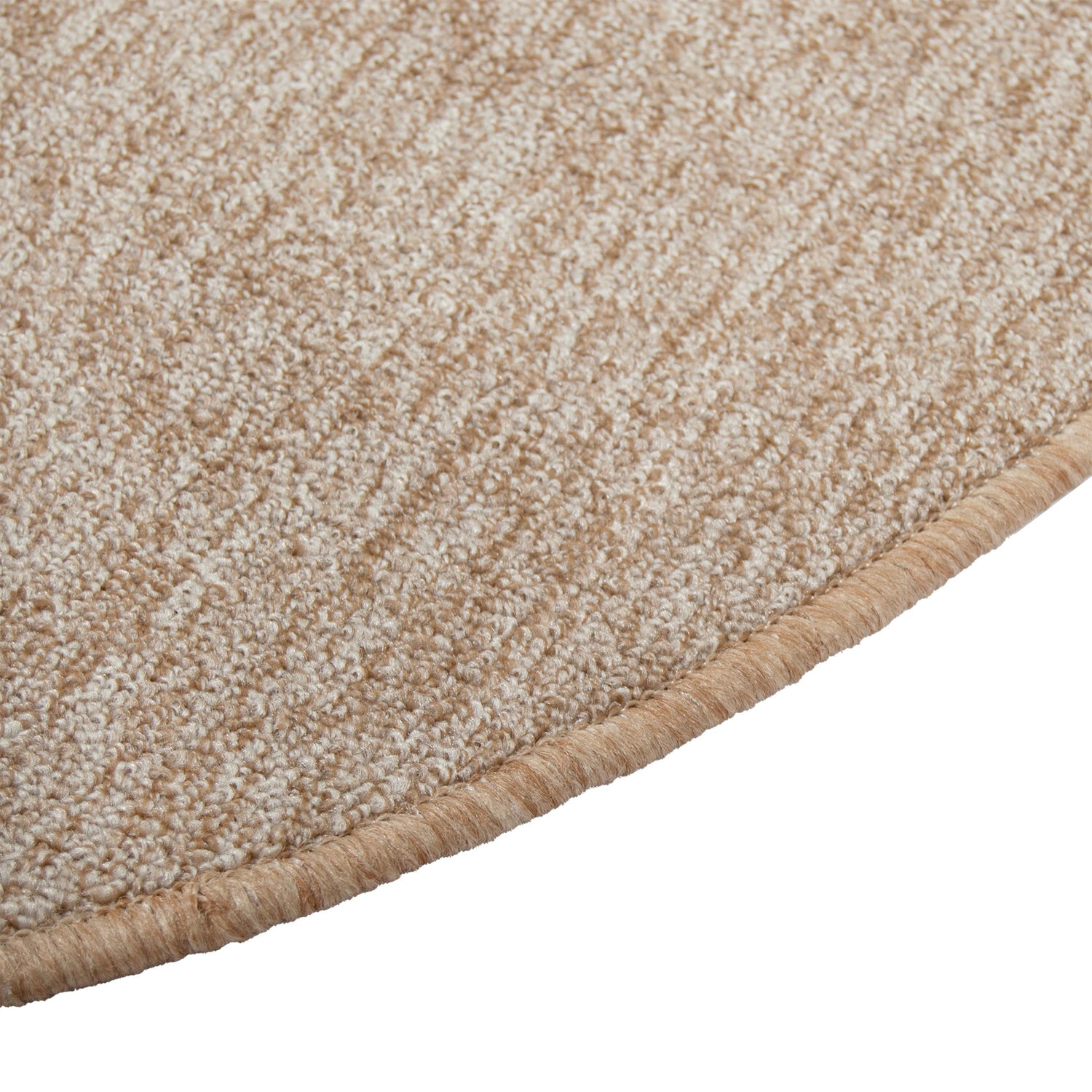 Lähikuvassa pyöreän Carina-maton reunausta - maton lämmin beige sävy, joka sisältää kevyttä meleerausta.