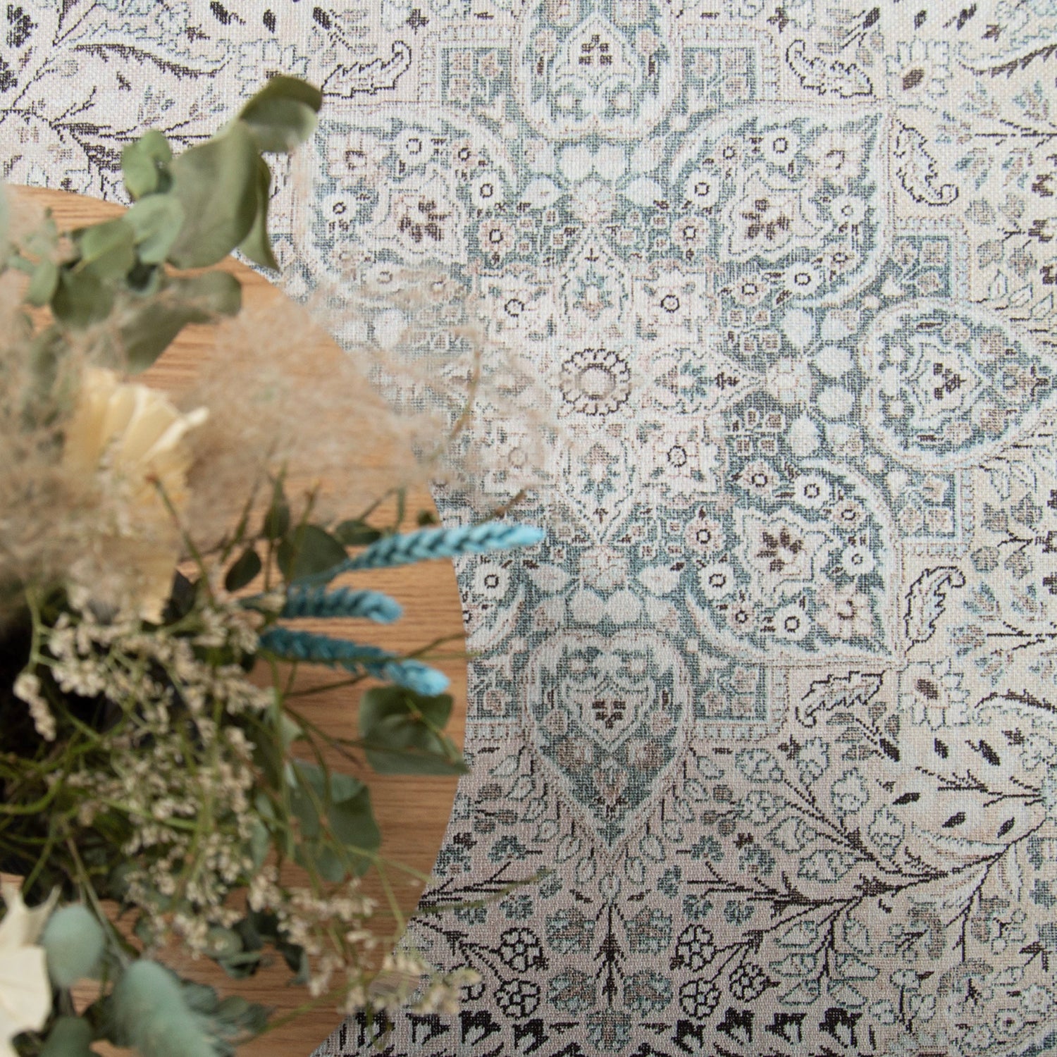 Kuvassa on Cecilia-maton beige-sinisen sävyinen itämainen kuosi kuvattuna sohvapöydän alla.