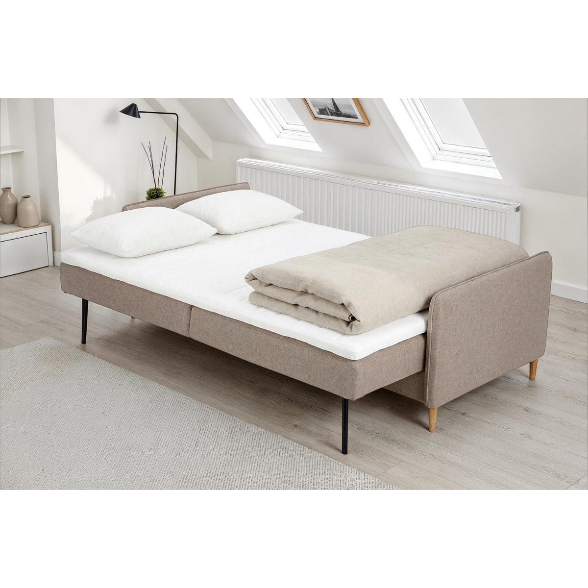 Kuvassa on Duo Plus -vuodesohva levitettynä vuoteeksi - verhoiluna beige Oasis 02 -kangasverhoilu ja luonnonväriset koivujalat.
