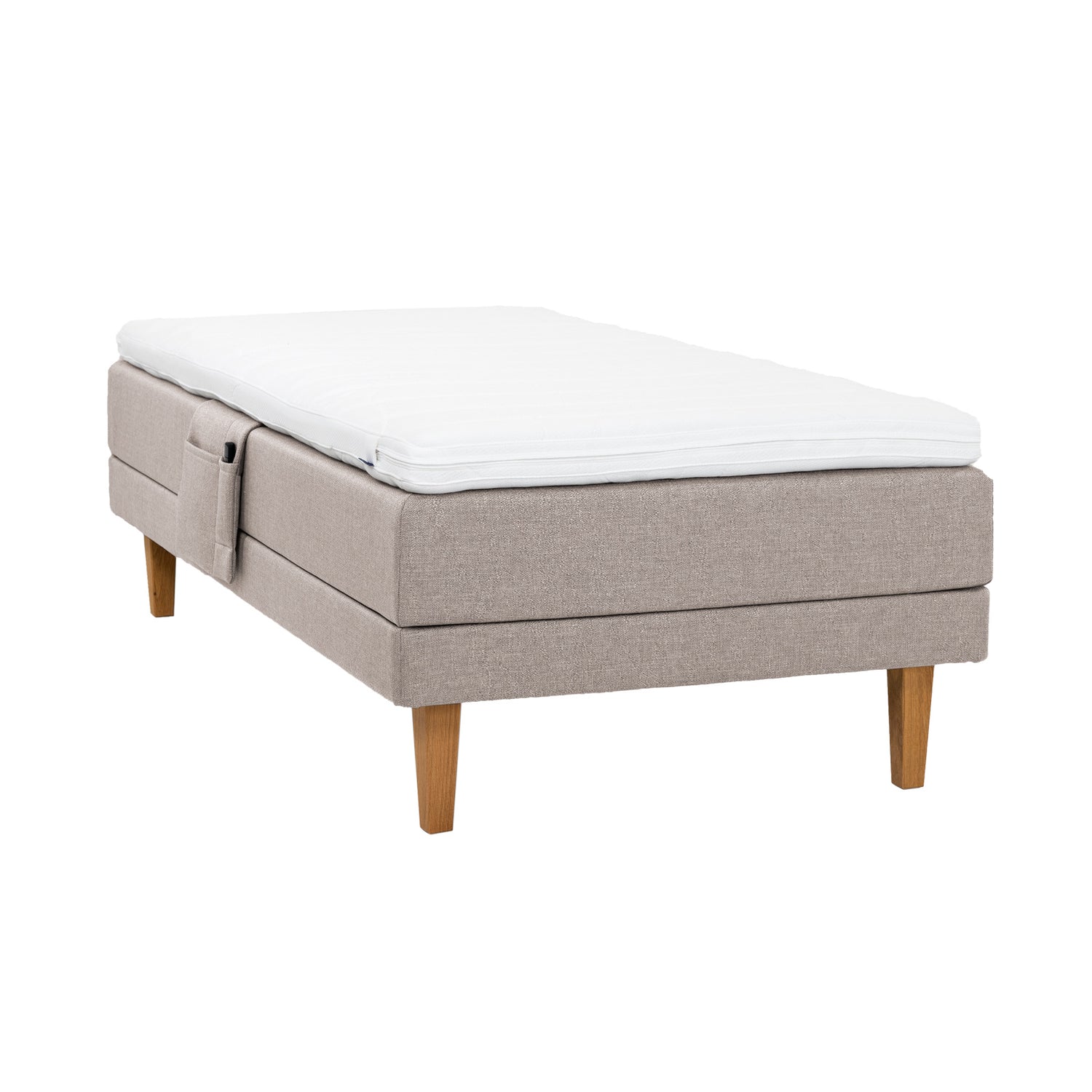 Beige Hilding Feel -moottorisänky 120 x 200 cm luonnonvärisillä 23 cm korkeilla Royal -tammijaloilla ja Hilding Hybrix Air Coolmax -sijauspatjalla. Kuvan tarviketasku myydään erikseen.