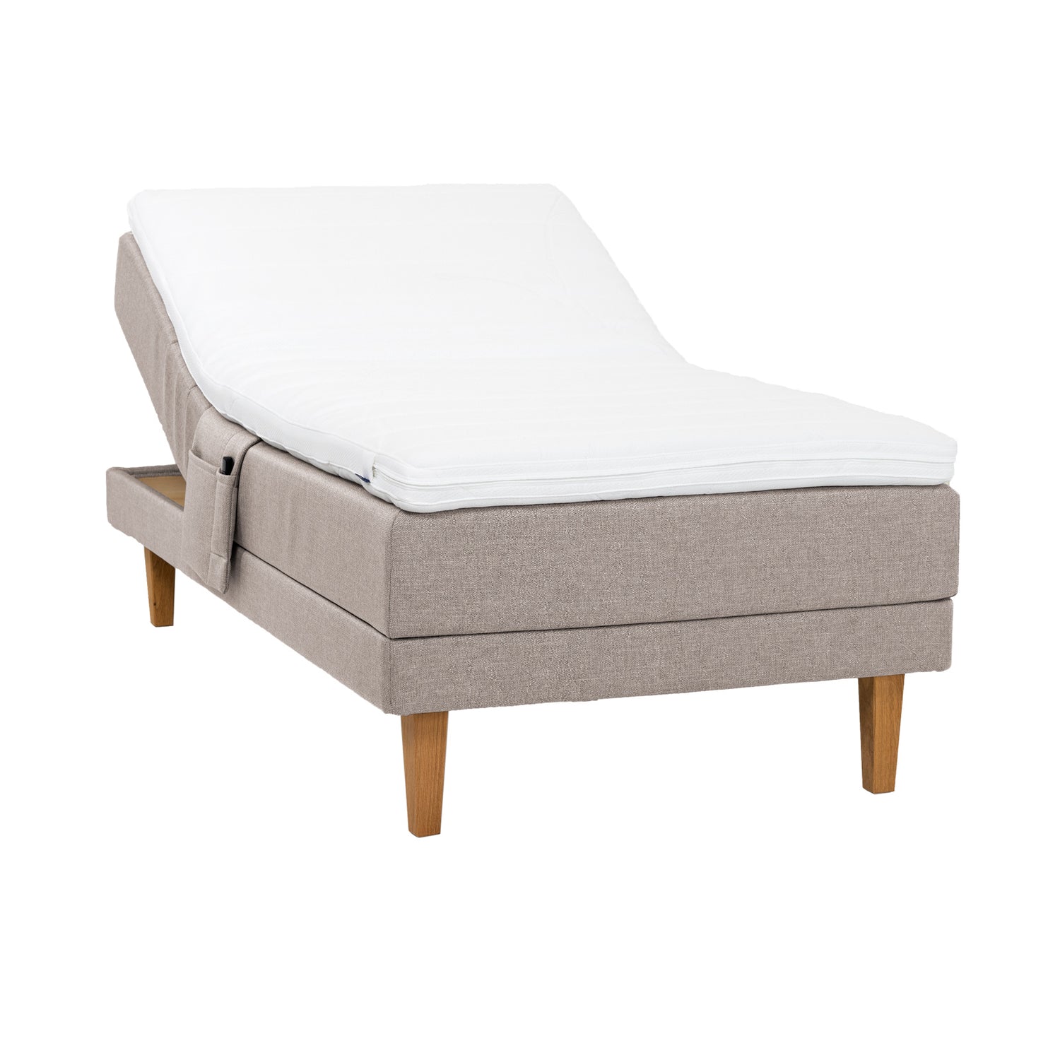 Beige Hilding Feel -moottorisänky 120 x 200 cm luonnonvärisillä 23 cm korkeilla Royal -tammijaloilla ja Hilding Hybrix Air Coolmax -sijauspatjalla. Kuvan tarviketasku myydään erikseen.