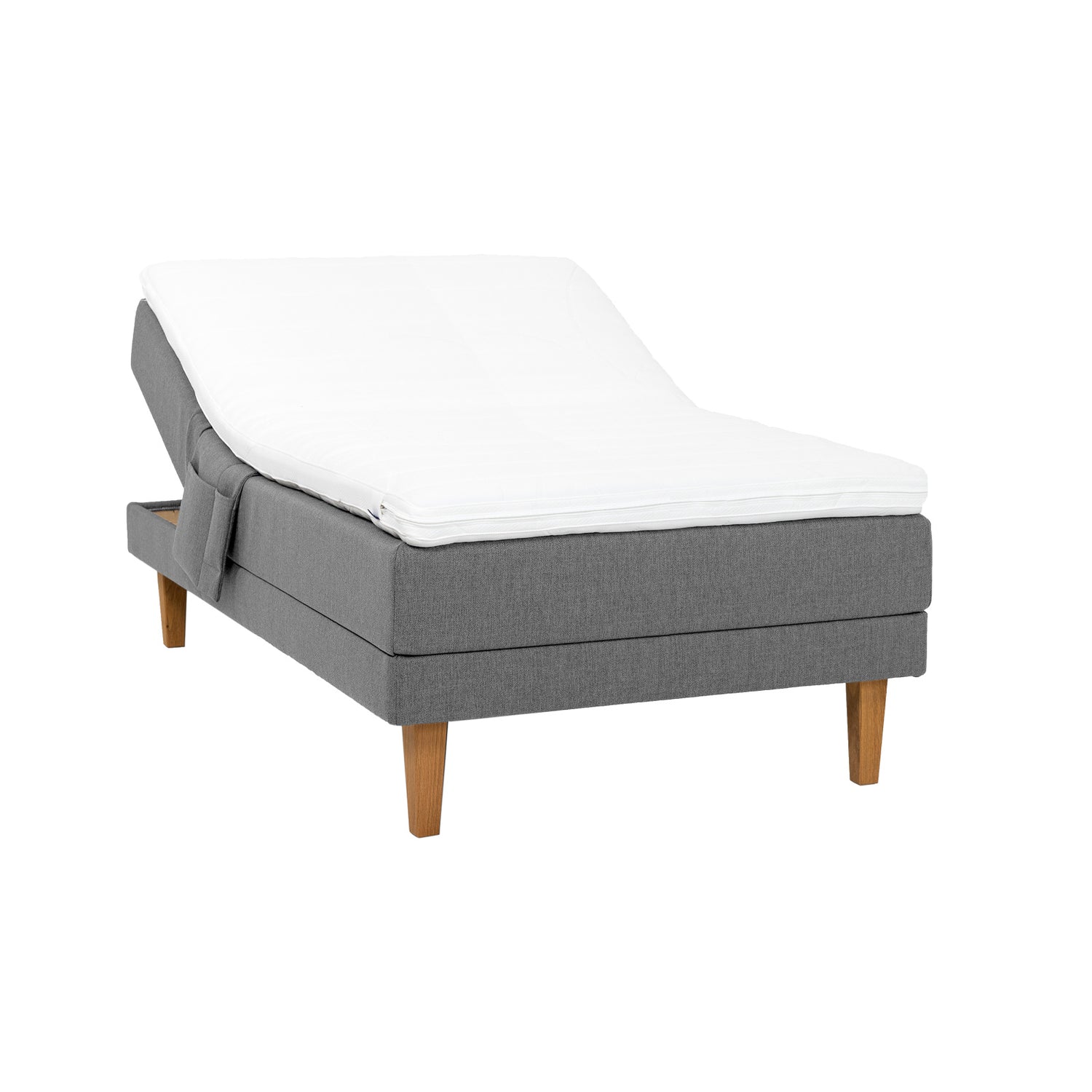 Harmaa Hilding Feel -moottorisänky 120 x 200 cm luonnonvärisillä 23 cm korkeilla Royal -tammijaloilla ja Hilding Hybrix Air Coolmax -sijauspatjalla. Kuvan tarviketasku myydään erikseen.