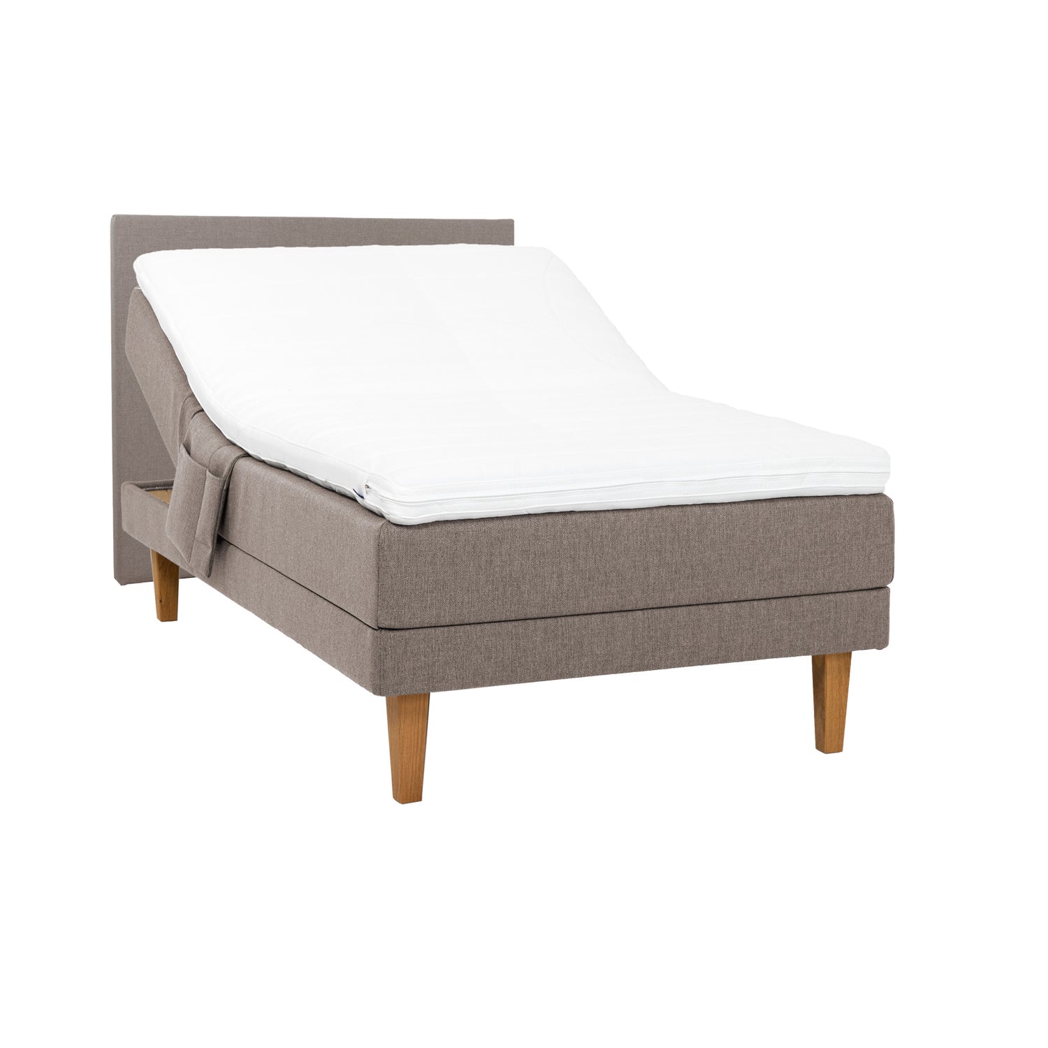 Hiekanvärinen Hilding Feel -moottorisänky 120 x 200 cm luonnonvärisillä 23 cm korkeilla Royal -tammijaloilla ja Hilding Hybrix Air Coolmax -sijauspatjalla. Kuvan sängynpääty tarviketasku myydään erikseen.