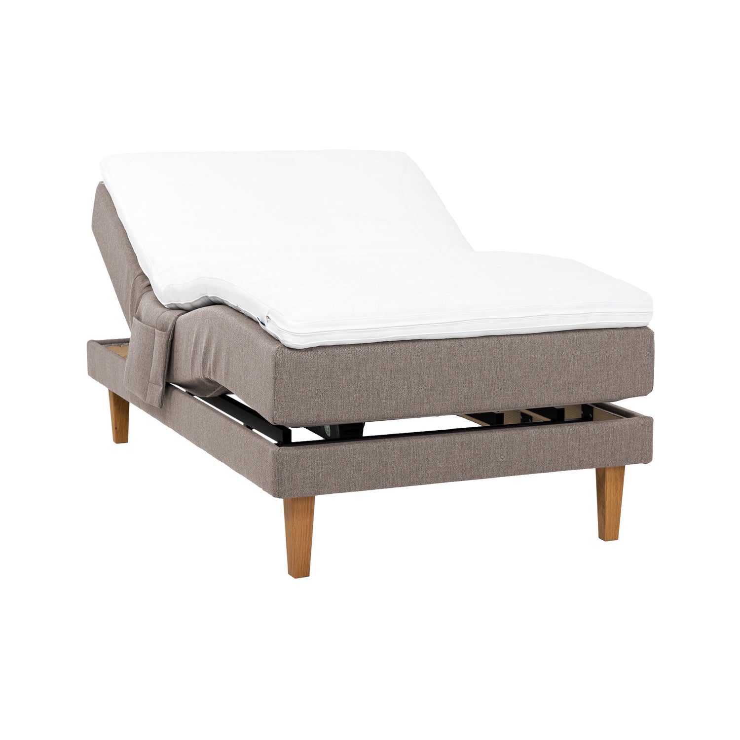 Hiekanvärinen Hilding Feel -moottorisänky 120 x 200 cm luonnonvärisillä 23 cm korkeilla Royal -tammijaloilla ja Hilding Hybrix Air Coolmax -sijauspatjalla. Kuvan tarviketasku myydään erikseen.