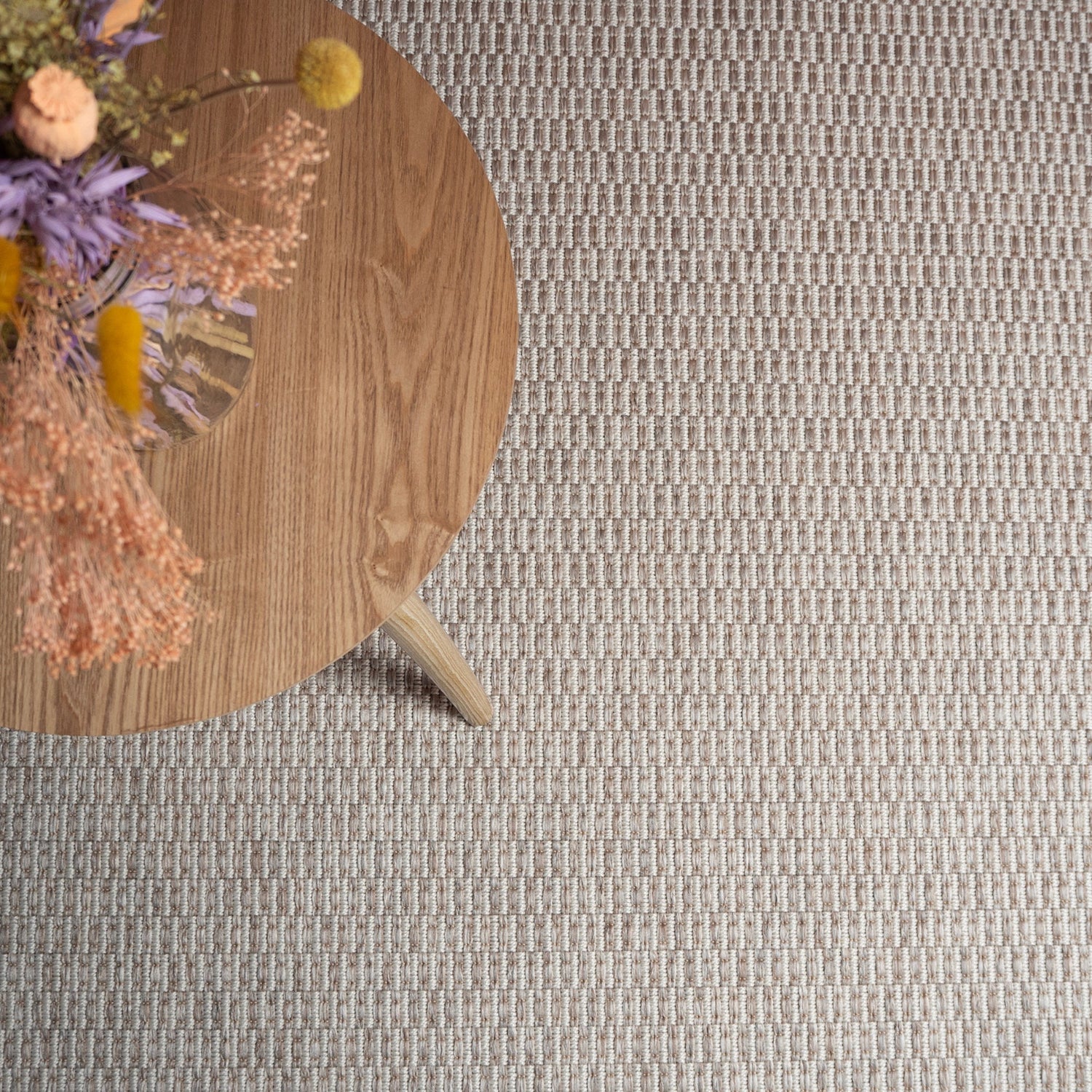 Kuvassa on luonnonvalkoinen Kaarna-matto kuvattuna sohvapöydän alla.