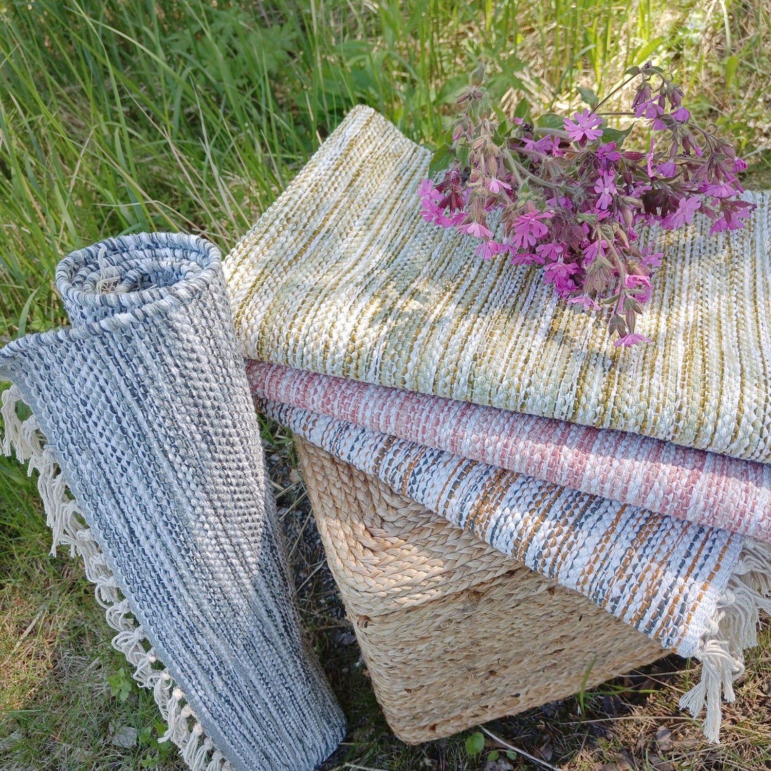 Kuvassa Kesälahti-puuvillamaton nimensä mukaisesti kesäiset sävyt: vasemmalla harmaa ja pinossa päältä alkaen vihreä, roosa ja harmaanruskea.