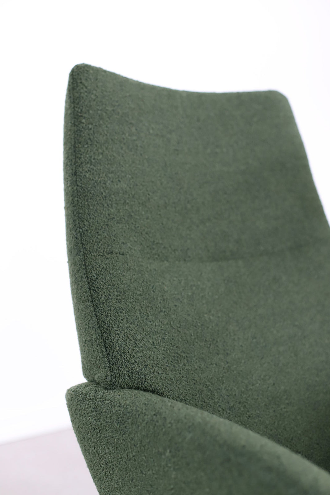 Lähikuvassa on Kebe Lotus -tv-tuoli vihreällä Alpine Forest 438 -kangasverhoilulla ja mustalla Vision -ristikkojalalla.