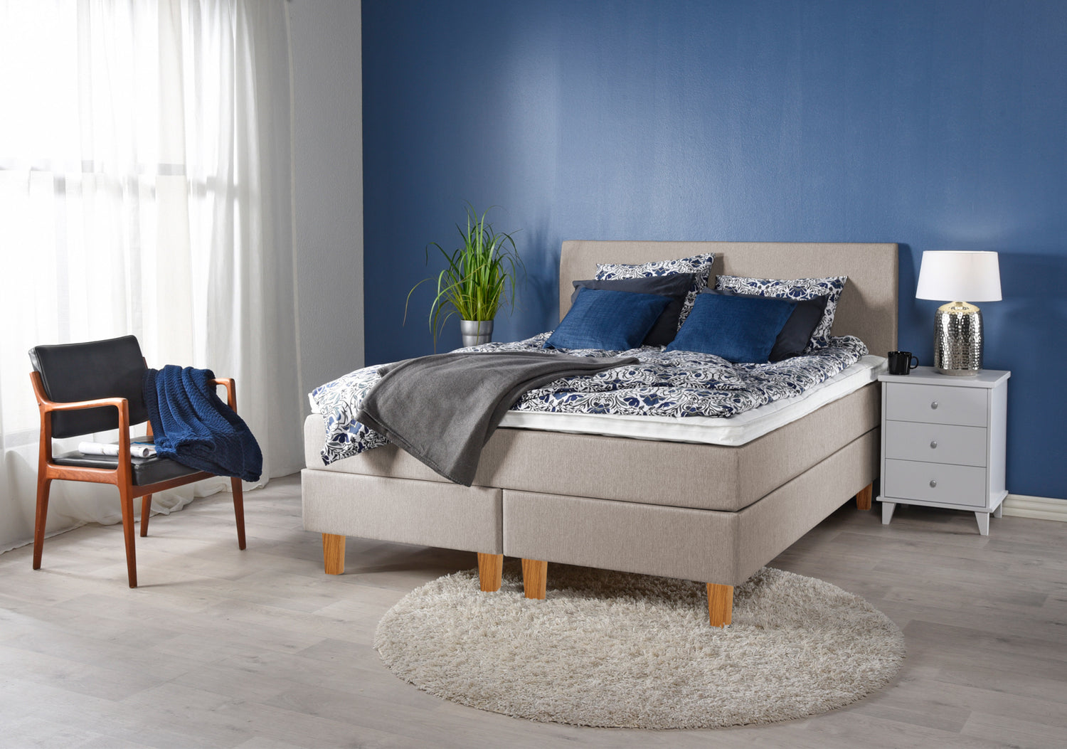 Ranta-jenkkisängyn beige sävy sopii monenlaiseen sisustukseen. Kuvassa beigenvärinen Ranta-jenkkisänky luonnonvärisillä Royal-tammijaloilla ja valkoisella profiloidulla sijauspatjalla. Kuvan sängynpääty myydään erikseen.