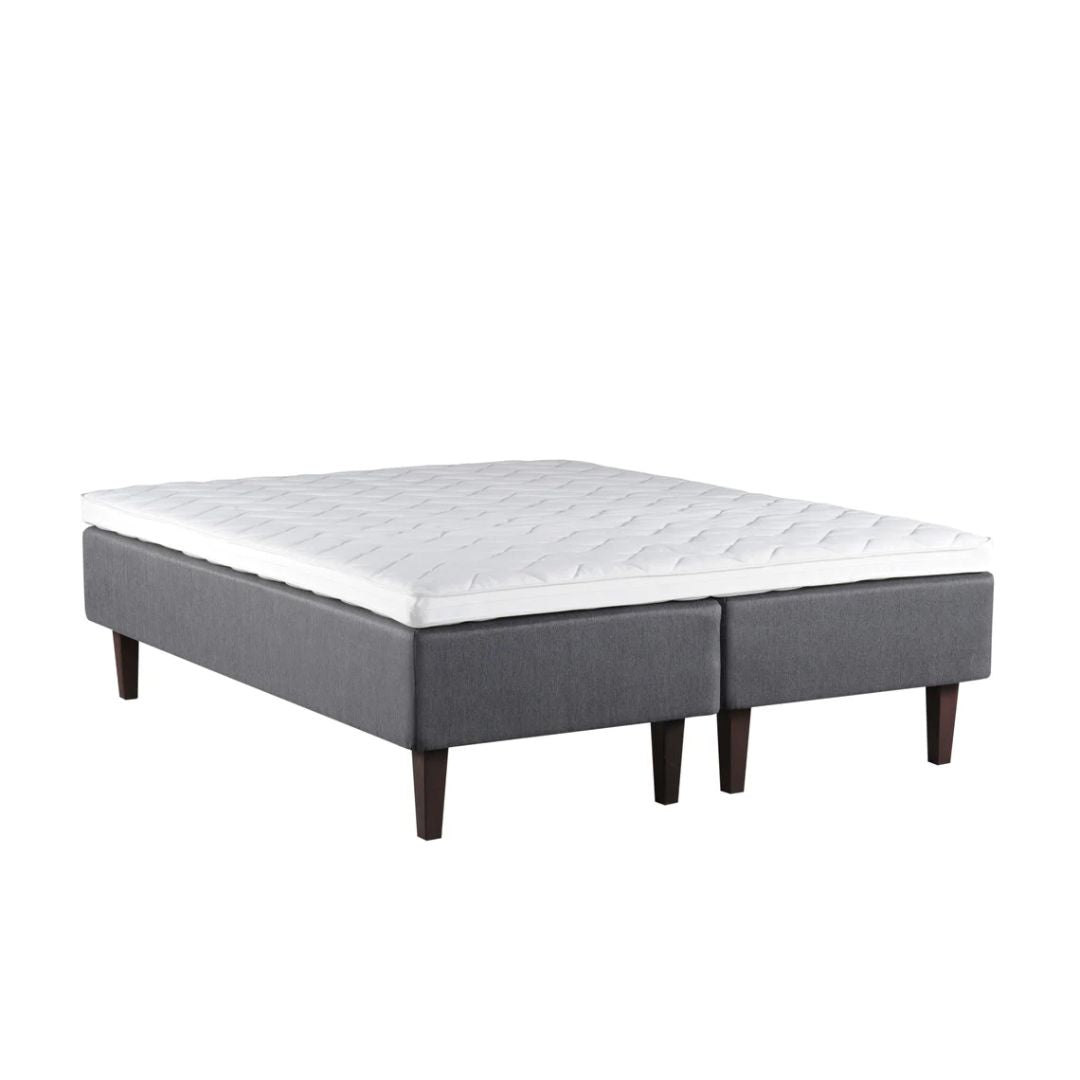 Harmaa Meri-runkopatja wengenvärisillä Royal-tammijaloilla ja profiloidulla sijauspatjalla.