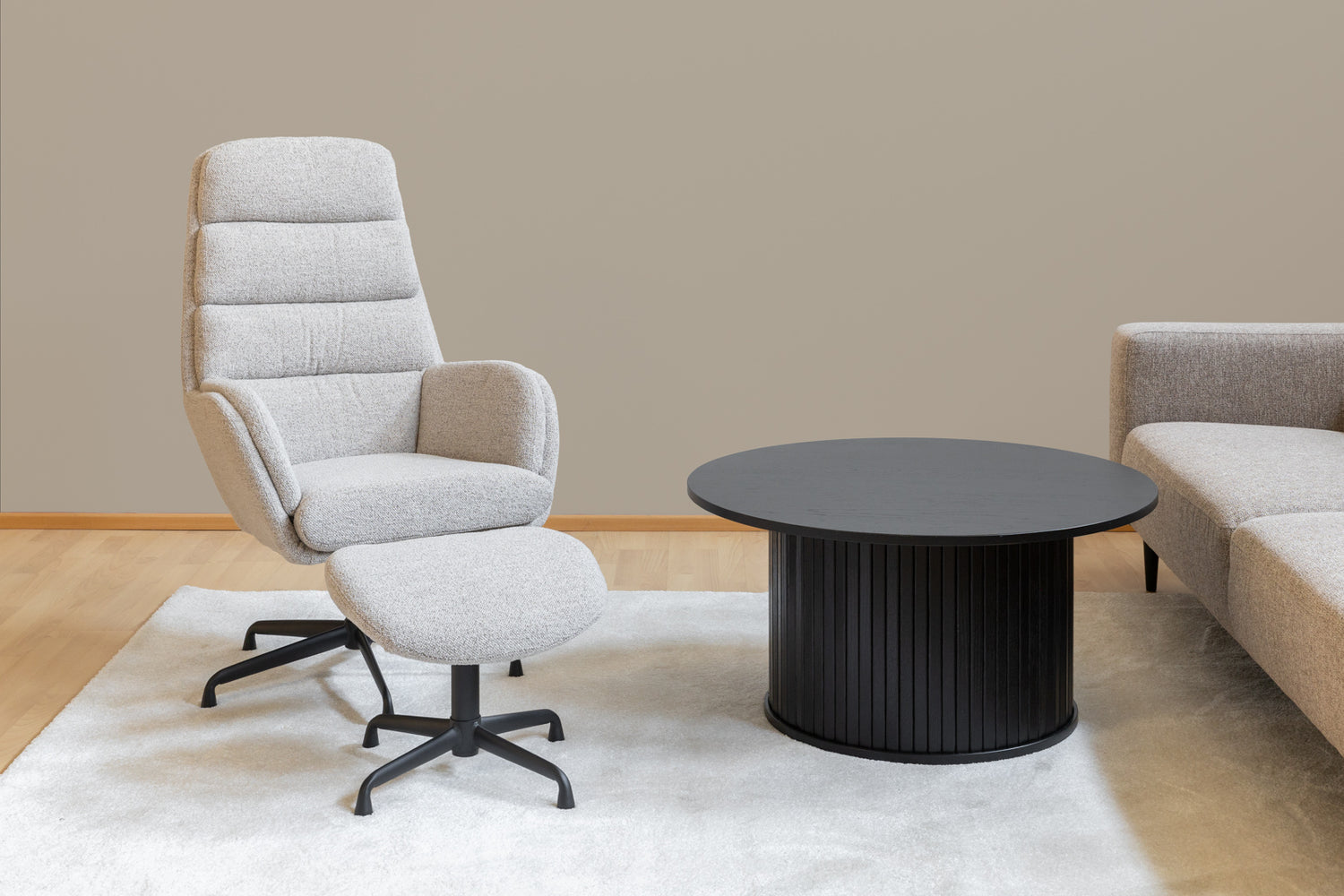 Kuvassa on Sifton tv-tuoli mustan Nola-sohvapöydän ja Tessa-sohvan kanssa kuvattuna. Mattokympin valkoinen Louna-matto kokoaa olohuoneen kalusteet kauniisti yhteen.