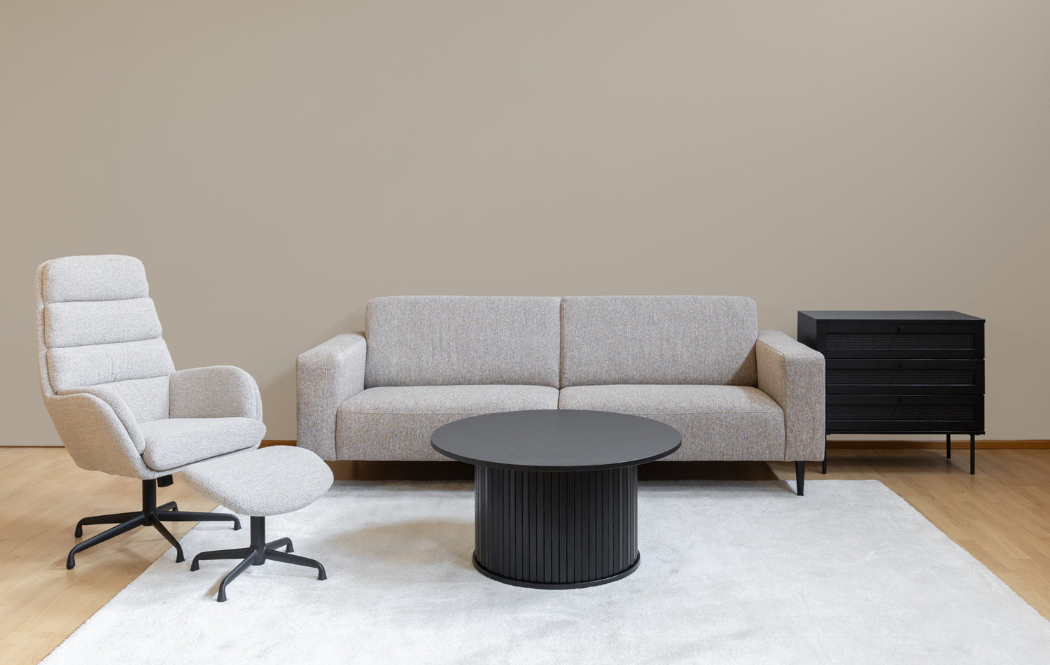 Kuvassa on mustat Nola-sohvapöytä ja Pensacola-lipasto kuvattuna Sifton tv-tuolin ja Tessa-sohvan kanssa - Mattokympin valkoinen Louna-matto kokoaa olohuoneen kalusteet kauniisti yhteen.