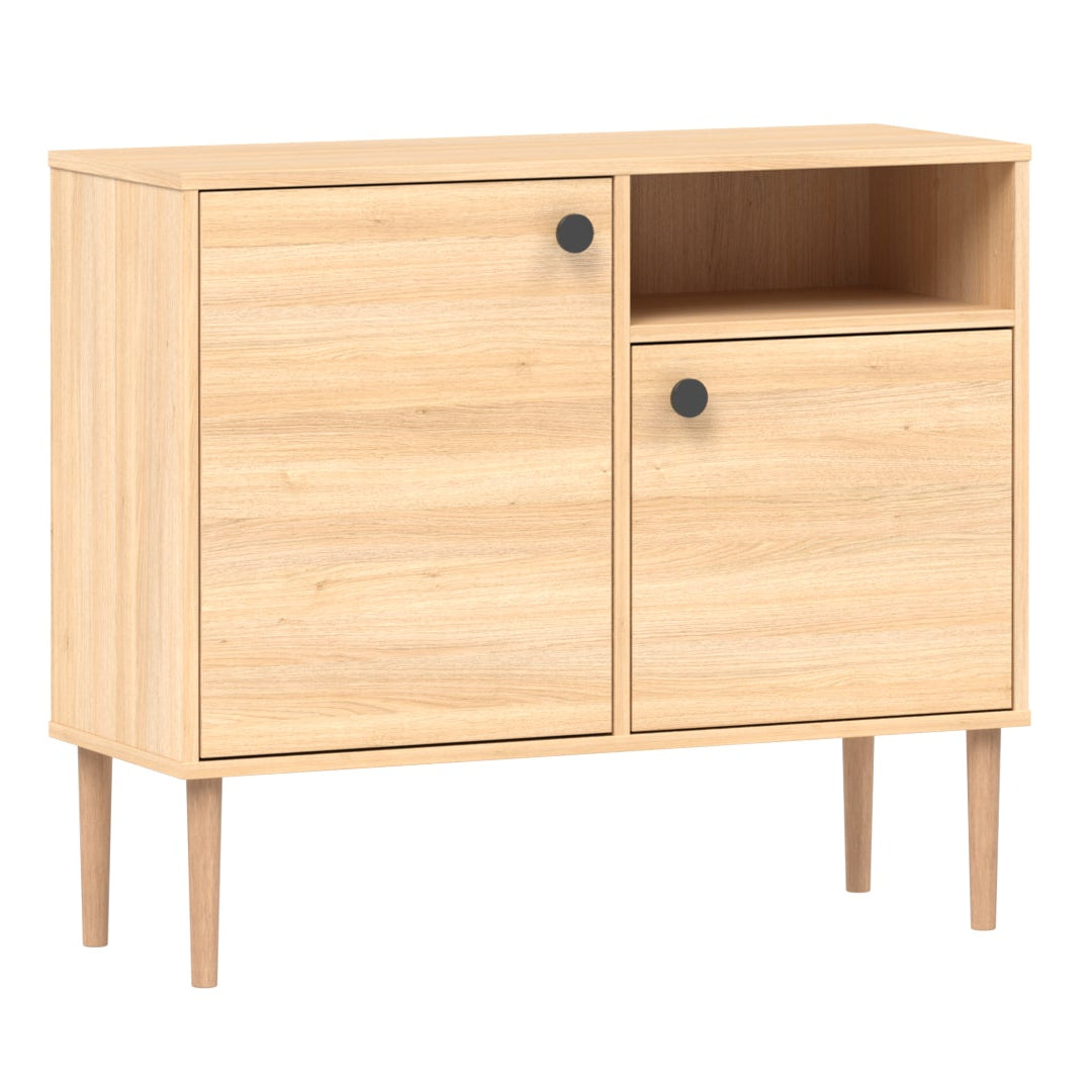 Tammenvärinen Stemma-lipastokaappi luonnonvärisillä tammijaloilla ja mustilla nuppivetimillä.