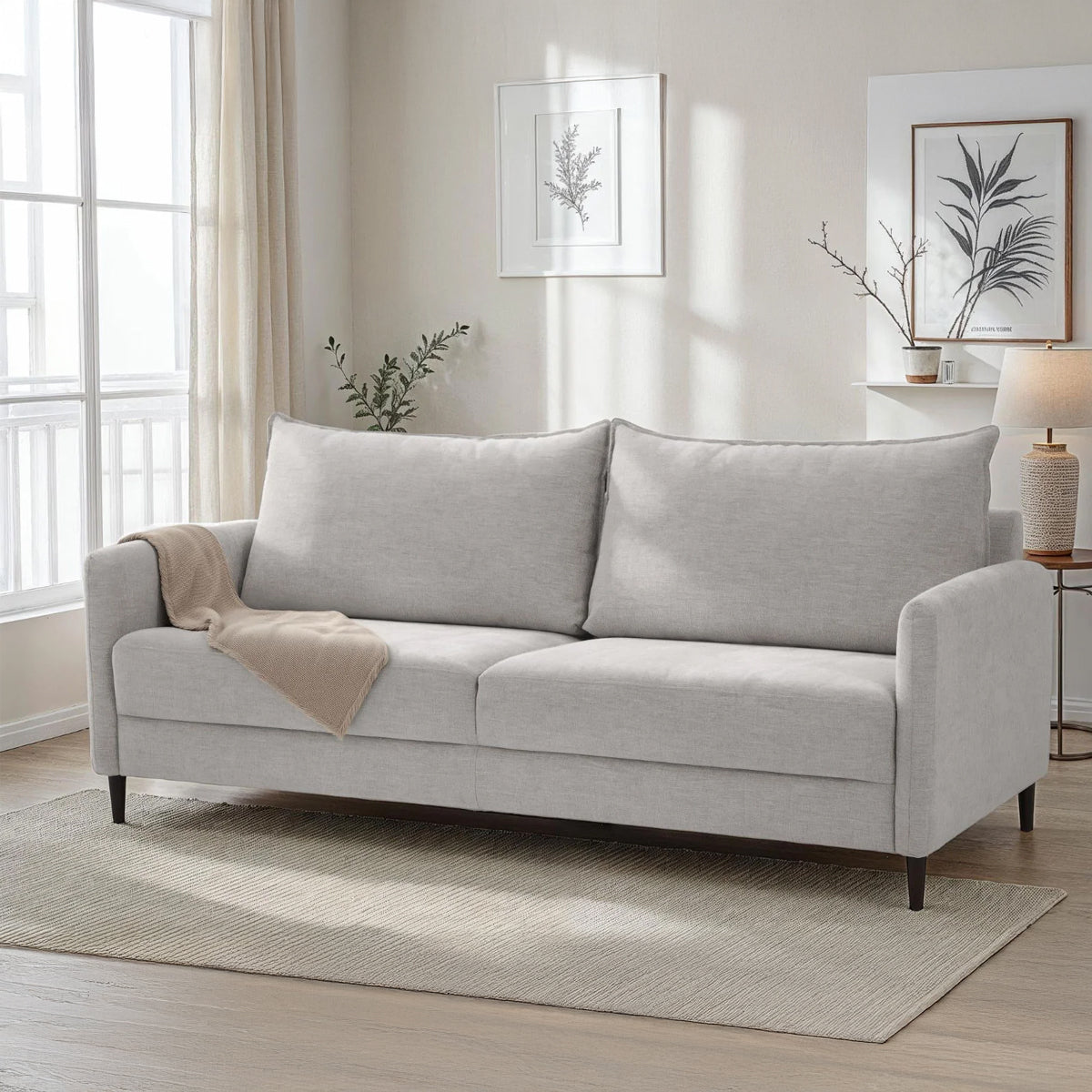 Kuvassa on 3-istuttava Stockholm-sohva vaalealla Oasis 01 -kankaalla ja 12 cm korkeilla wengenvärisillä puujaloilla.