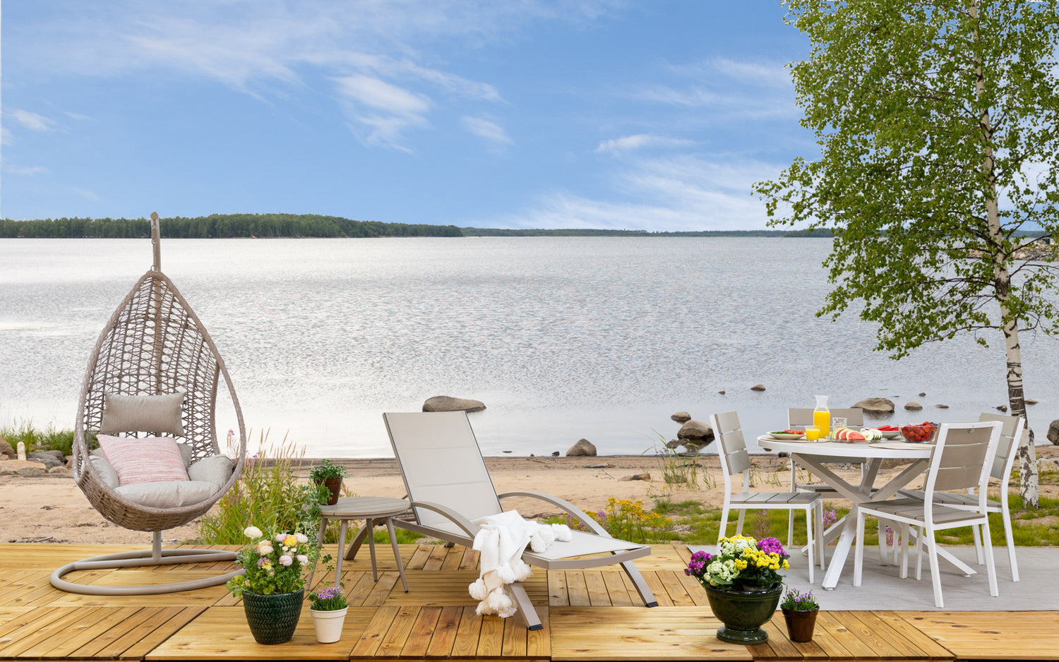 Kuvassa on pyöreä beige-valkoinen Suvi Aintwood -ruokaryhmä (huom, kuvattuna käsinojattomilla tuoleilla, mutta pakettiin kuuluu käsinojat). Lisäksi kuvassa Suvi-riippukeinu, Suvi-sohvapöytä ja Suvi Textiline -aurinkotuoli. Kuvassa myös Mattokympin pellavanvärinen Pilke-matto ja valkoinen Sävel Tupsu -torkkupeitto.