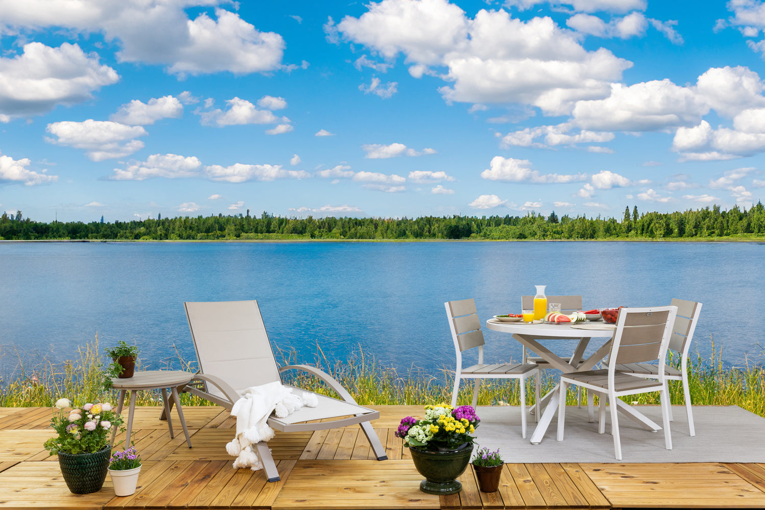 Kuvassa on pyöreä beige-valkoinen Suvi Aintwood-ruokaryhmä erikseen myytävien Suvi Textiline -aurinkotuolin ja Suvi-sohvapöydän kanssa. Kuvassa lisäksi Mattokympin pellavanvärinen Pilke-matto ja valkoinen Sävel Tupsu -torkkupeitto.