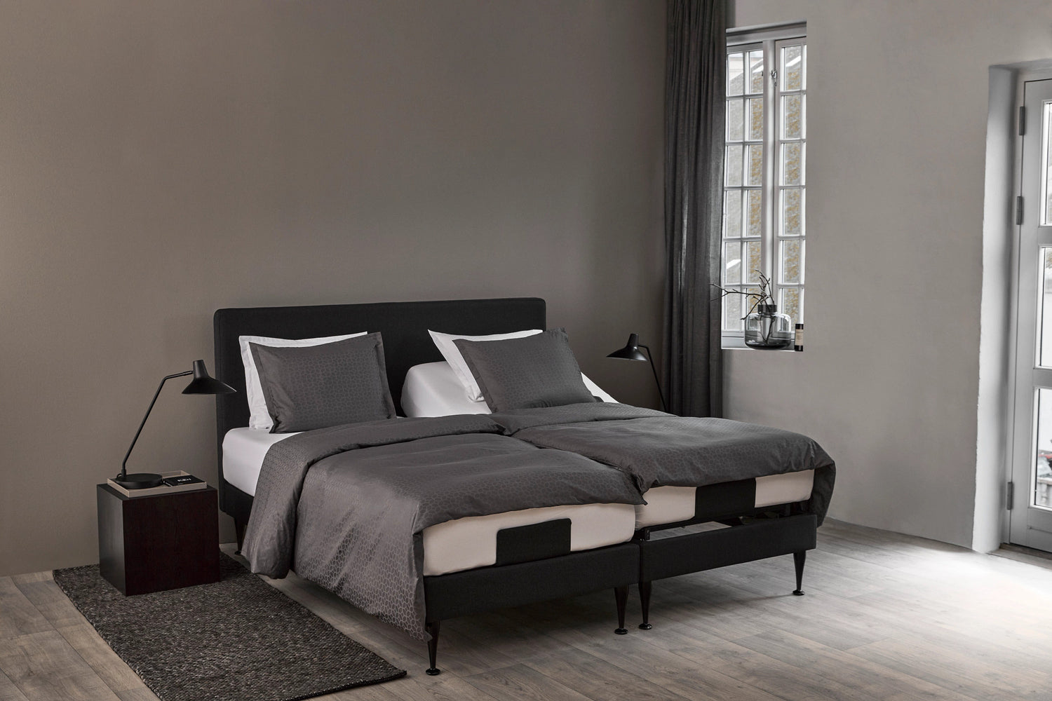 Kuvassa on hiilenmustalla Charcoal Grey -kankaalla verhoillut Tempur Move-säätövuoteet parisänkypakettina Tempur Pro SmartCool patjoilla. Kuvan sänkyjen vuoderungoissa on erikseen myytävät 19 cm Design-jalat, sängynpääty sekä vuodevaatteet.