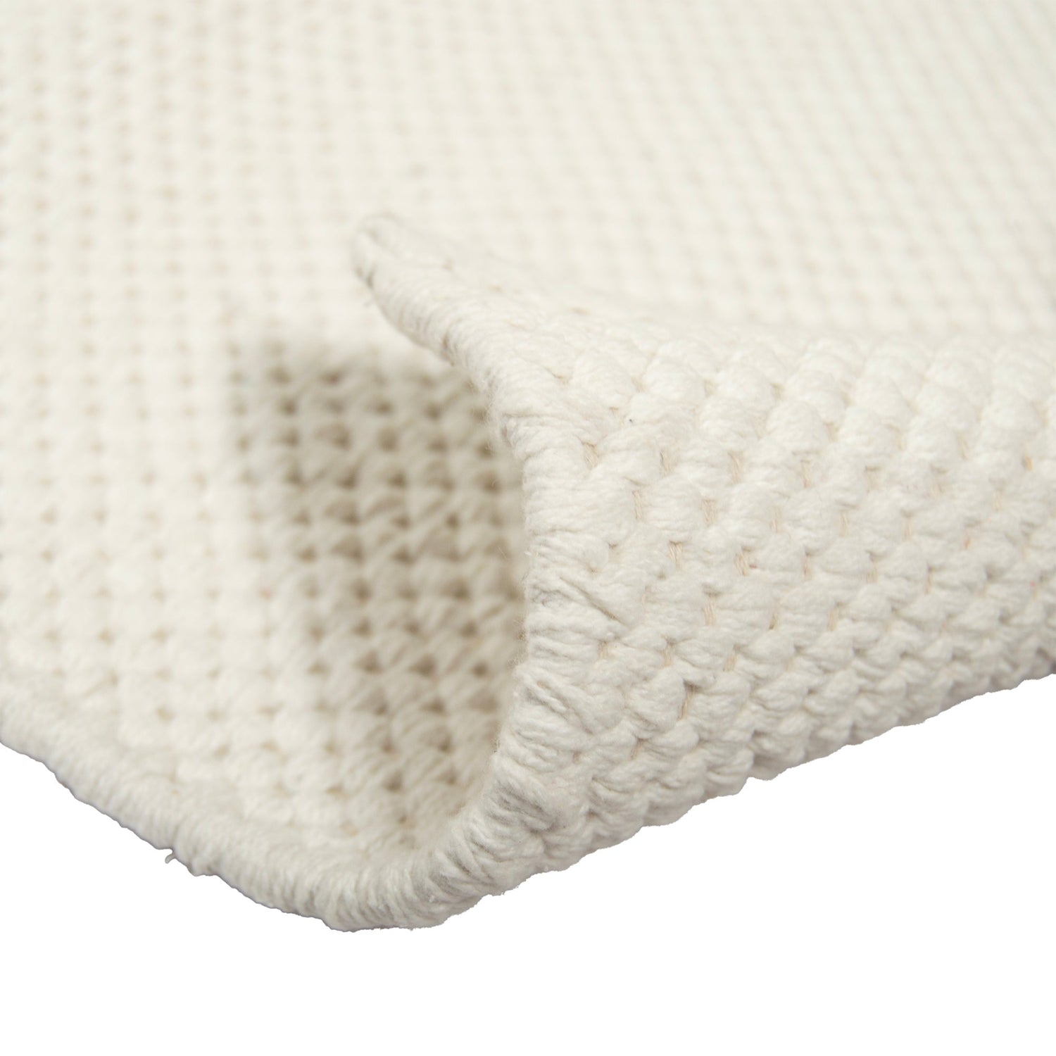 Lähikuvassa molemmin puolin pidettävä Ulappa-puuvillamatto, valkoinen.