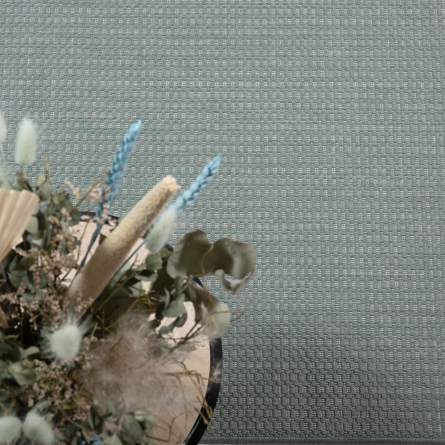 Kuvassa on sileäksi kudottu Vuono-matto, vihreä. Matto on kuvattu sohvapöydän alla.