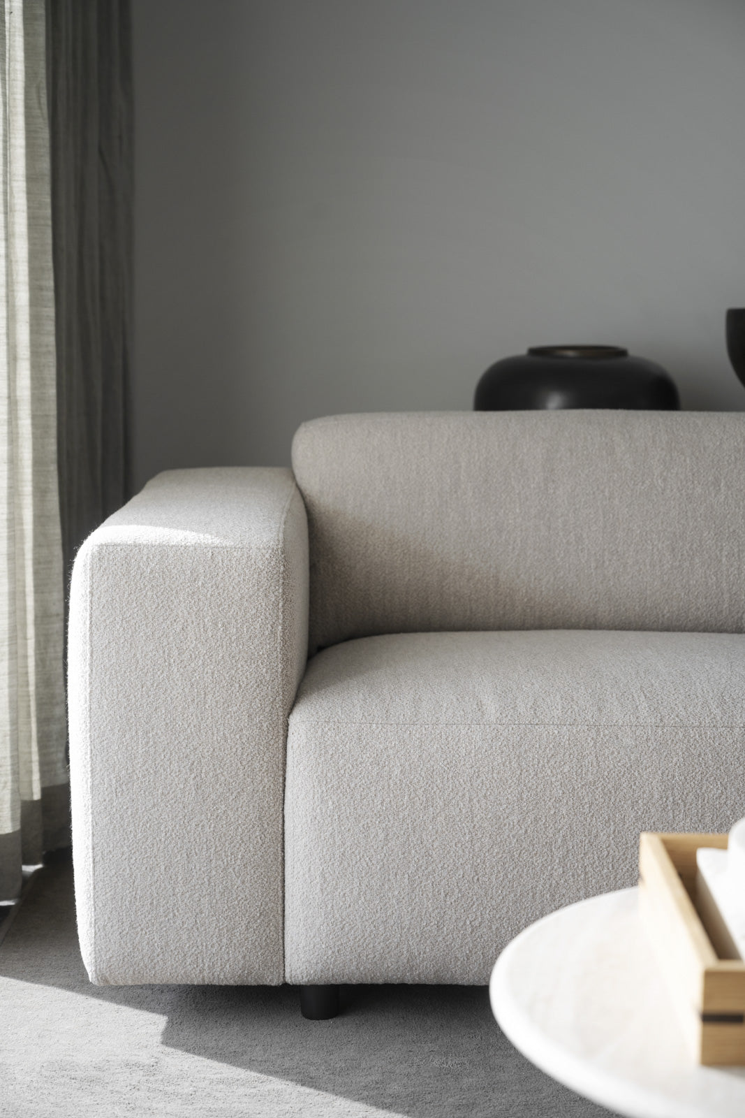 Kuvassa on kolmen istuttava Willard-divaanisohva vaaleanbeigellä Alice 01 -kankaalla ja mustilla muovijaloilla.