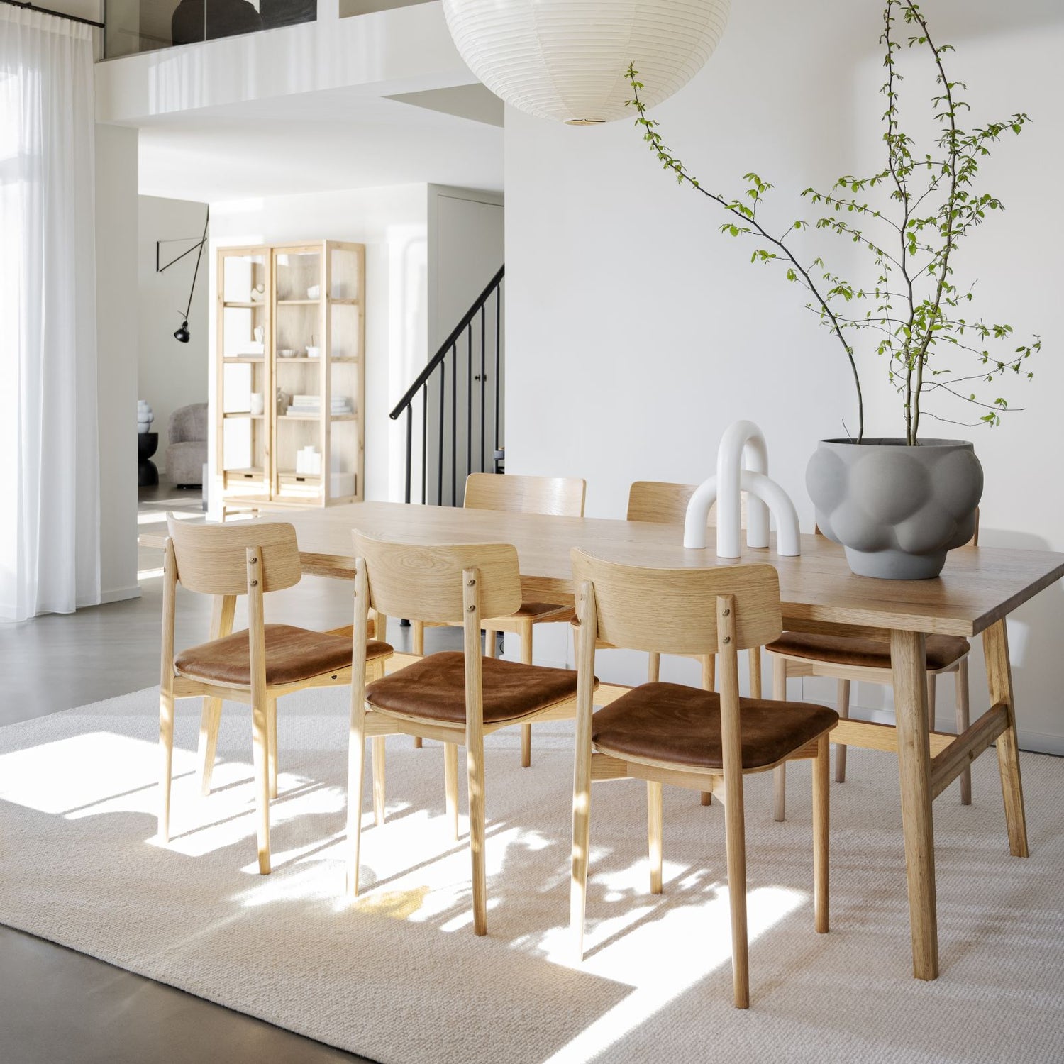 Tammenvärinen Plainfield-ruokapöytä. (Kuvassa myös erikseen myytävät Wolcott-tuolit ja taustalla Hazelton-lasikaappi).