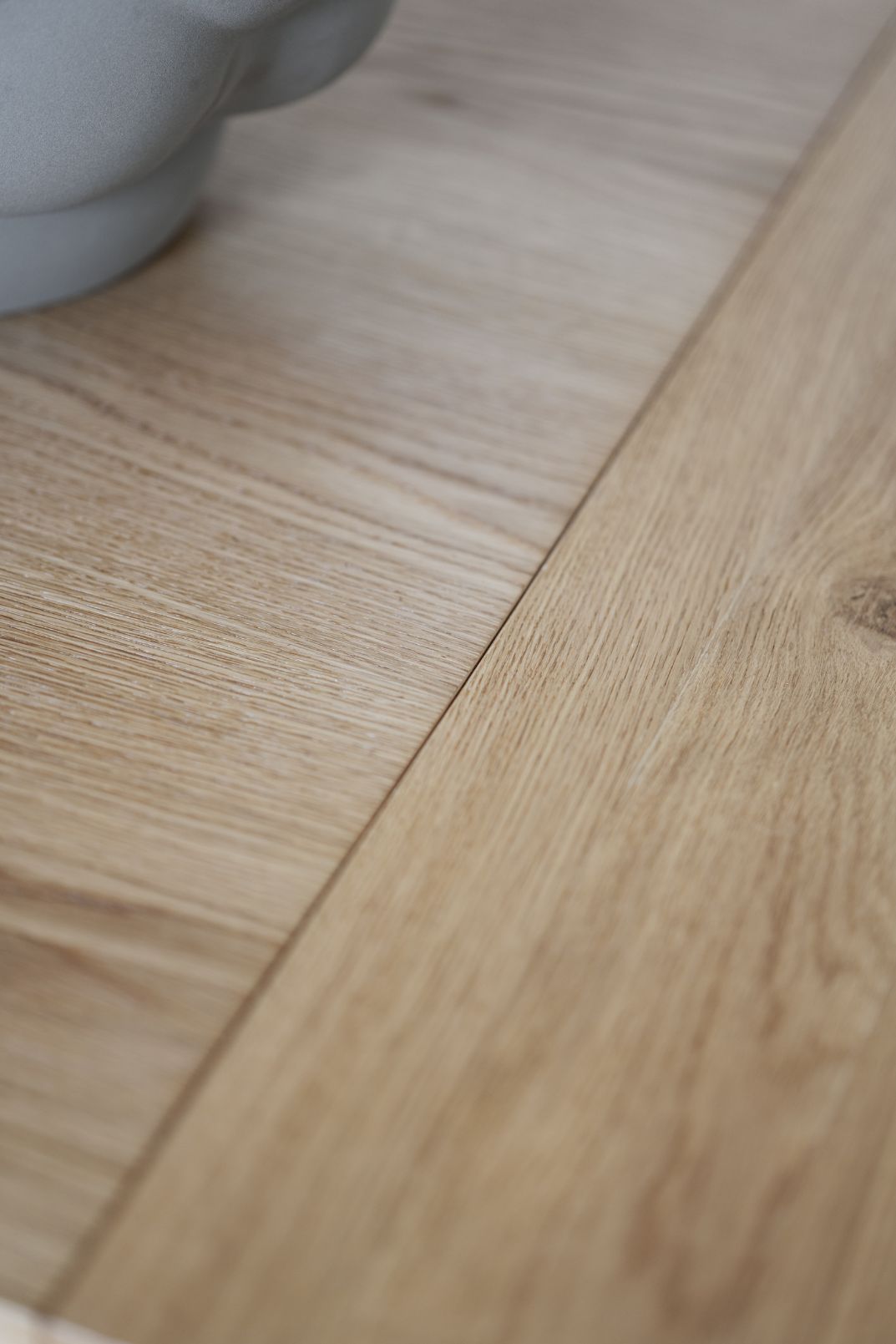 Lähikuvassa tammenvärisen Plainfield-jatkolevyn liitos.