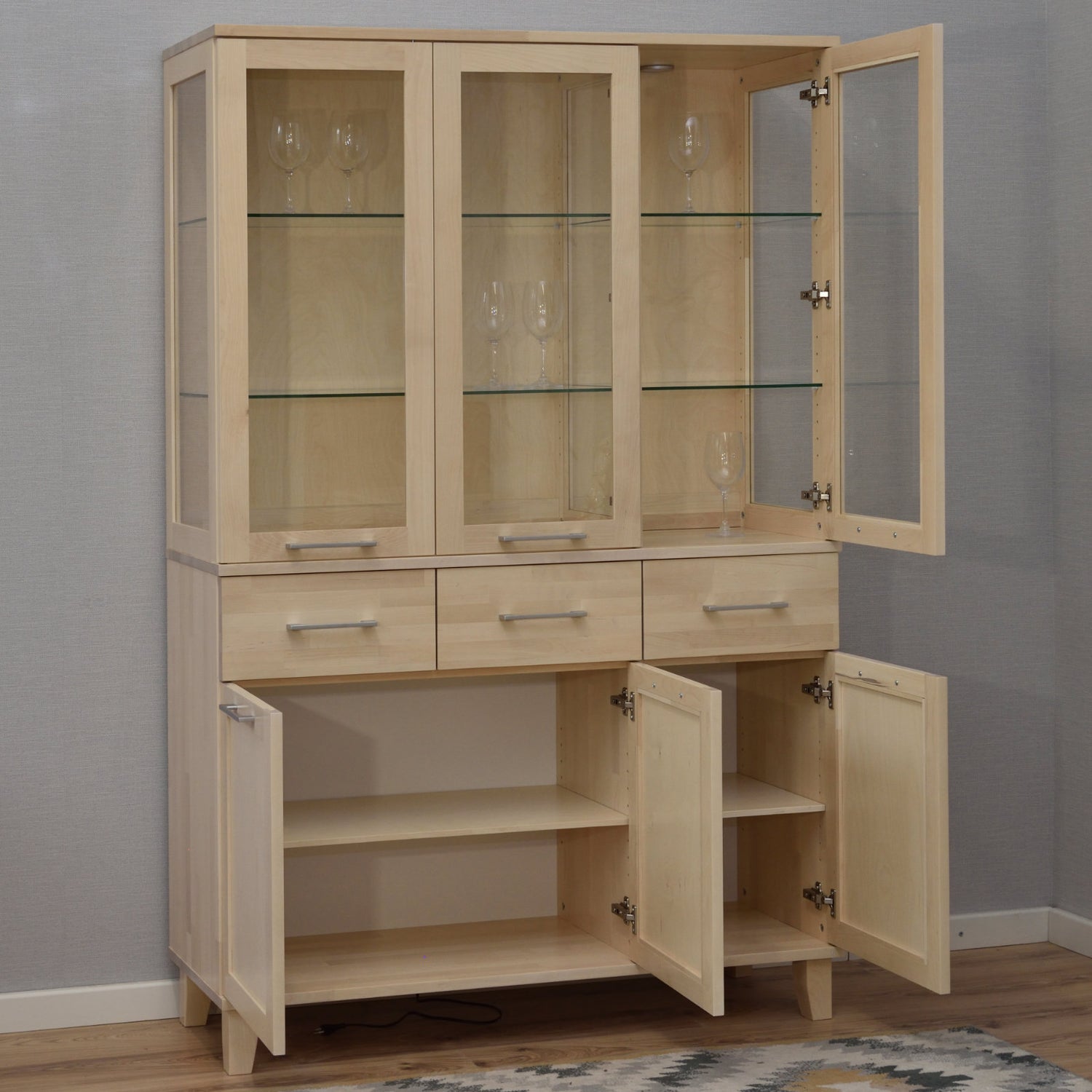 Kuvassa on valkolakattu Vuokatti-vitriini. Vitriinissä on lasikaapisto lasihyllyillä, alaosan tilava senkki kaappien peiliovilla, sekä pitkänmalliset RST-vetimet. Vitriinin sisällä olevat valot/viinilasit eivät kuulu senkin hintaan.