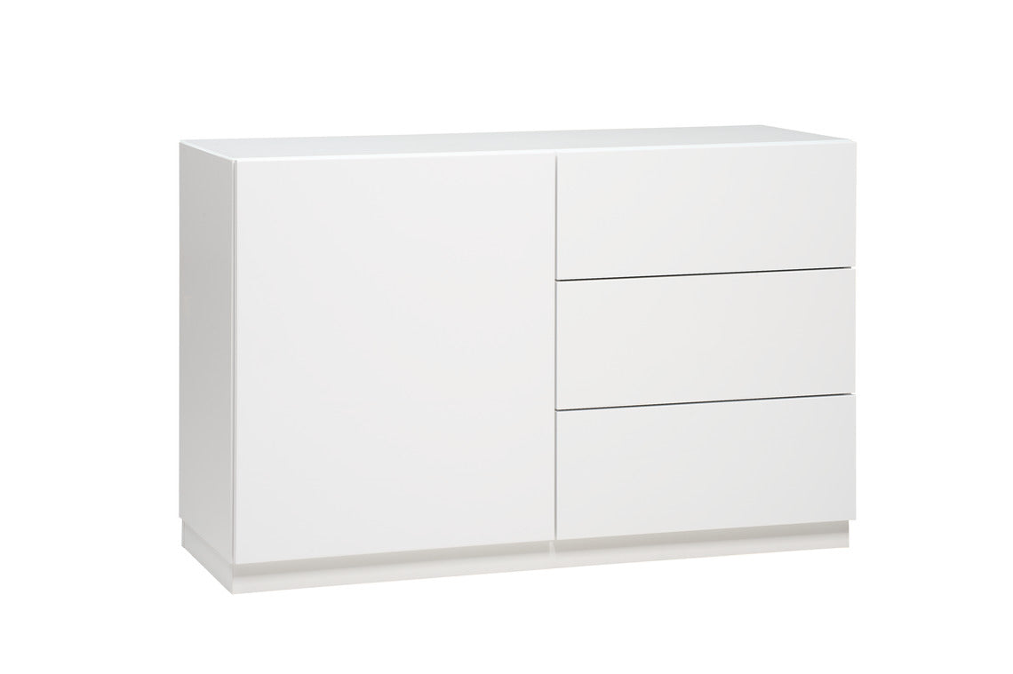 Kuvassa on 120 cm leveä korkeakiiltovalkoinen Lumo-senkki valkoisella jalkasokkelilla. Sarjan tuotteissa on valkoinen lasikansi.