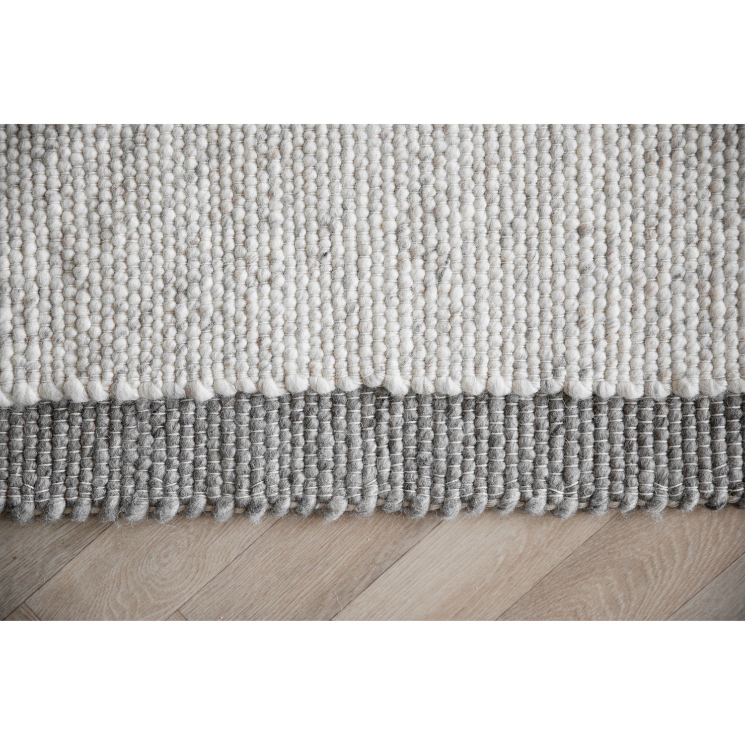 Lähikuva luonnonvalkoisesta ja harmaasta Auckland-villamatosta.