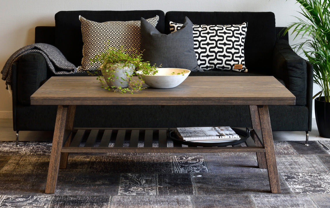 Tummissa Brooklyn-kalusteissa on harjattu pinta ja viimeistelynä sävytelakka. Kuvan sohvapöytä on savutammenvärinen.