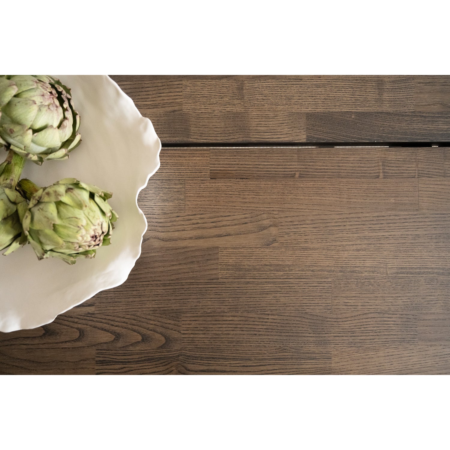 Lähikuvassa on Carradale-ruokapöydän savutammenvärinen kansi, jonka keskellä lankkujen välissä on rako.