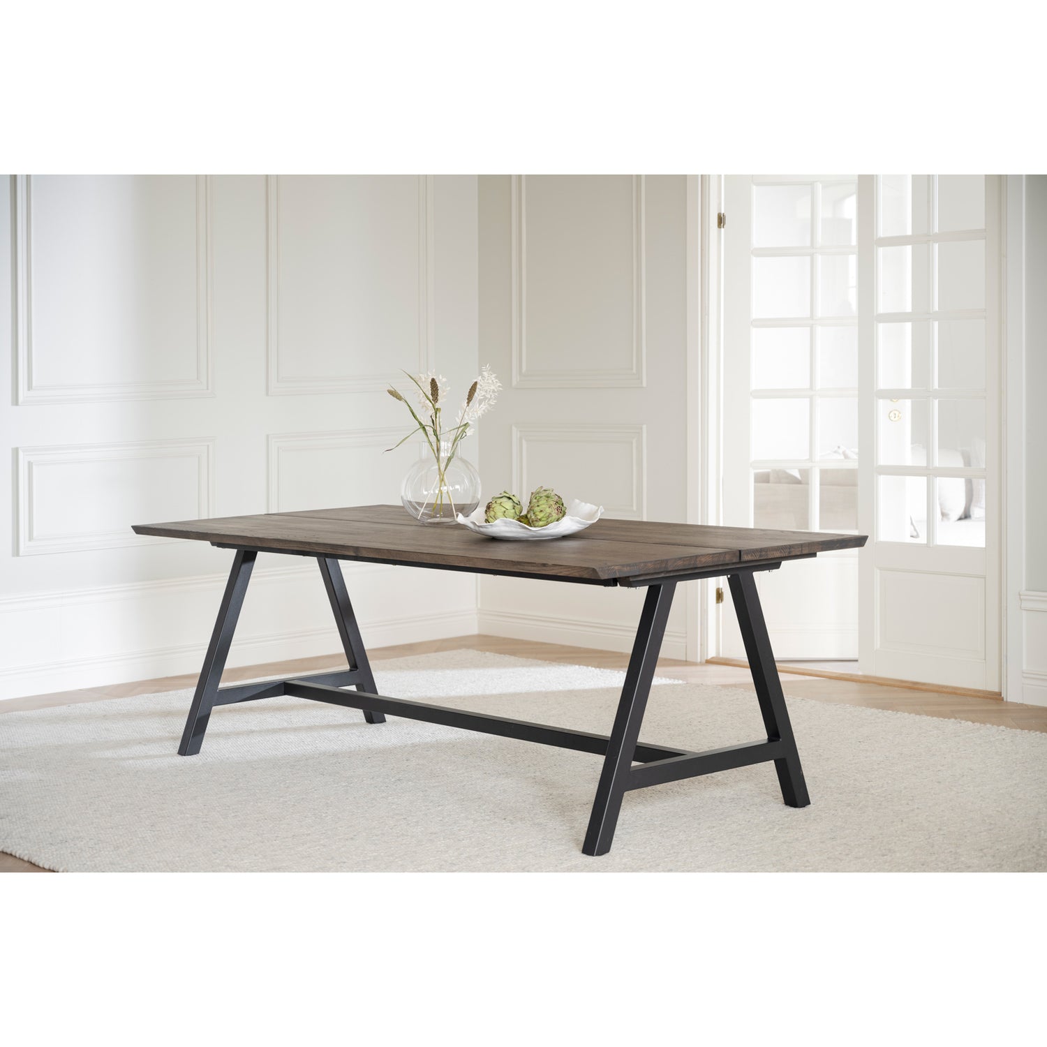 Kuvassa on Carradale-ruokapöytä savutammenvärisellä kannella ja mustilla A-mallisilla metallijaloilla.