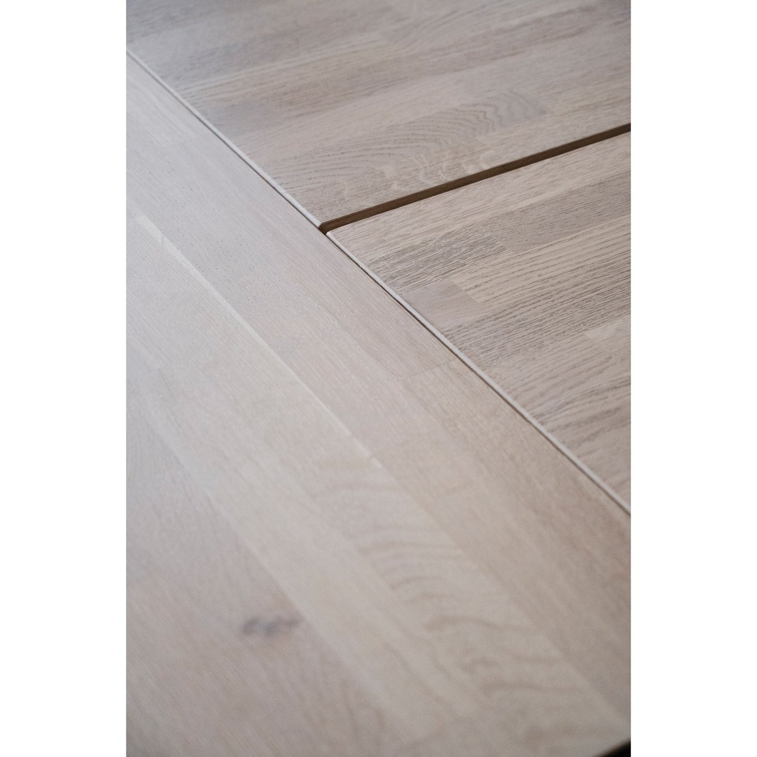 Lähikuvassa valkotammenvärisen Carradale-lankkupöydän kansi, jota on jatkettu erikseen myytävällä yhtenäisellä jatkopalalla.