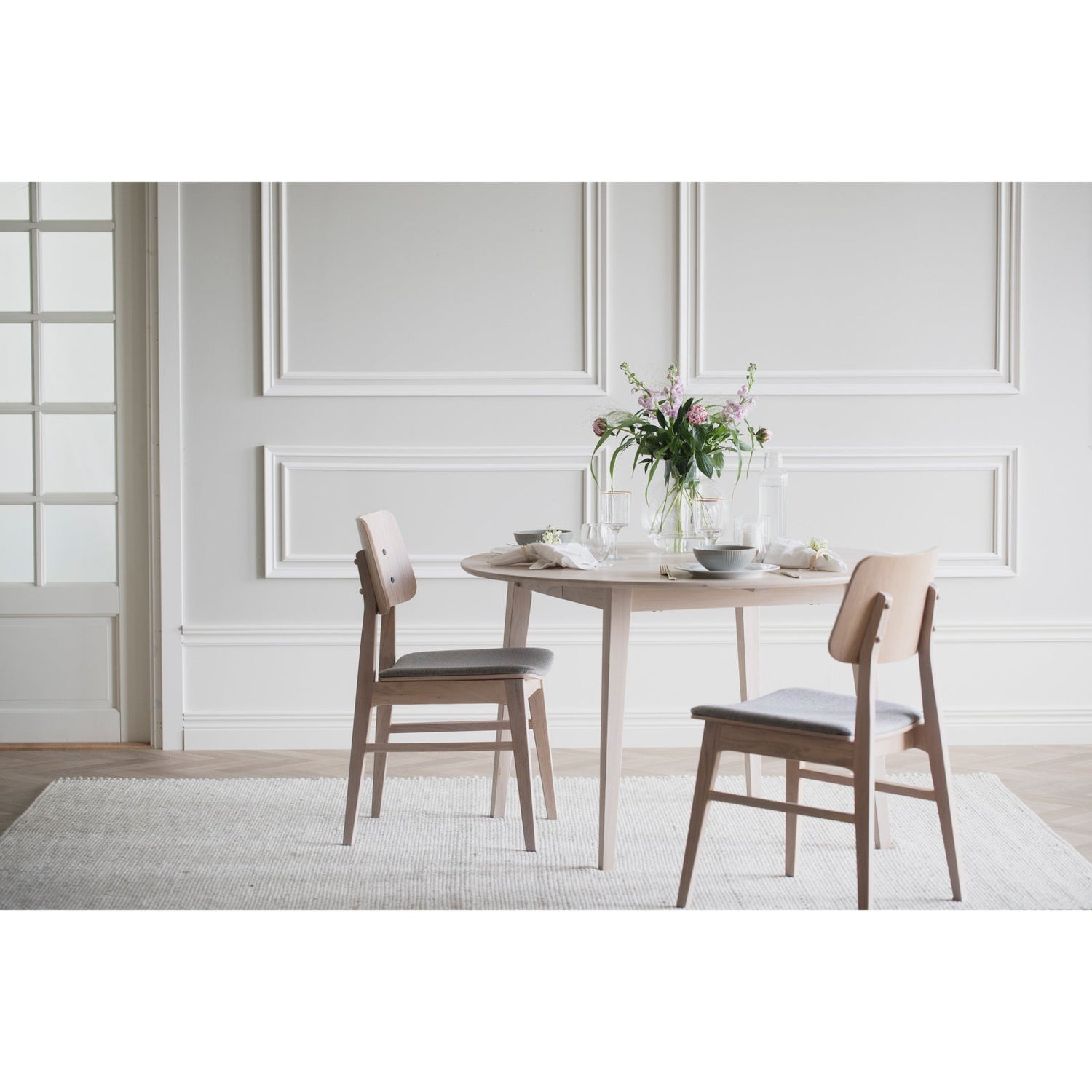 Kuvassa on pyöreä Filippa-ruokapöytä valkotammenvärisenä, sekä Rowicon erikseen myytävät Nagano-tuolit.