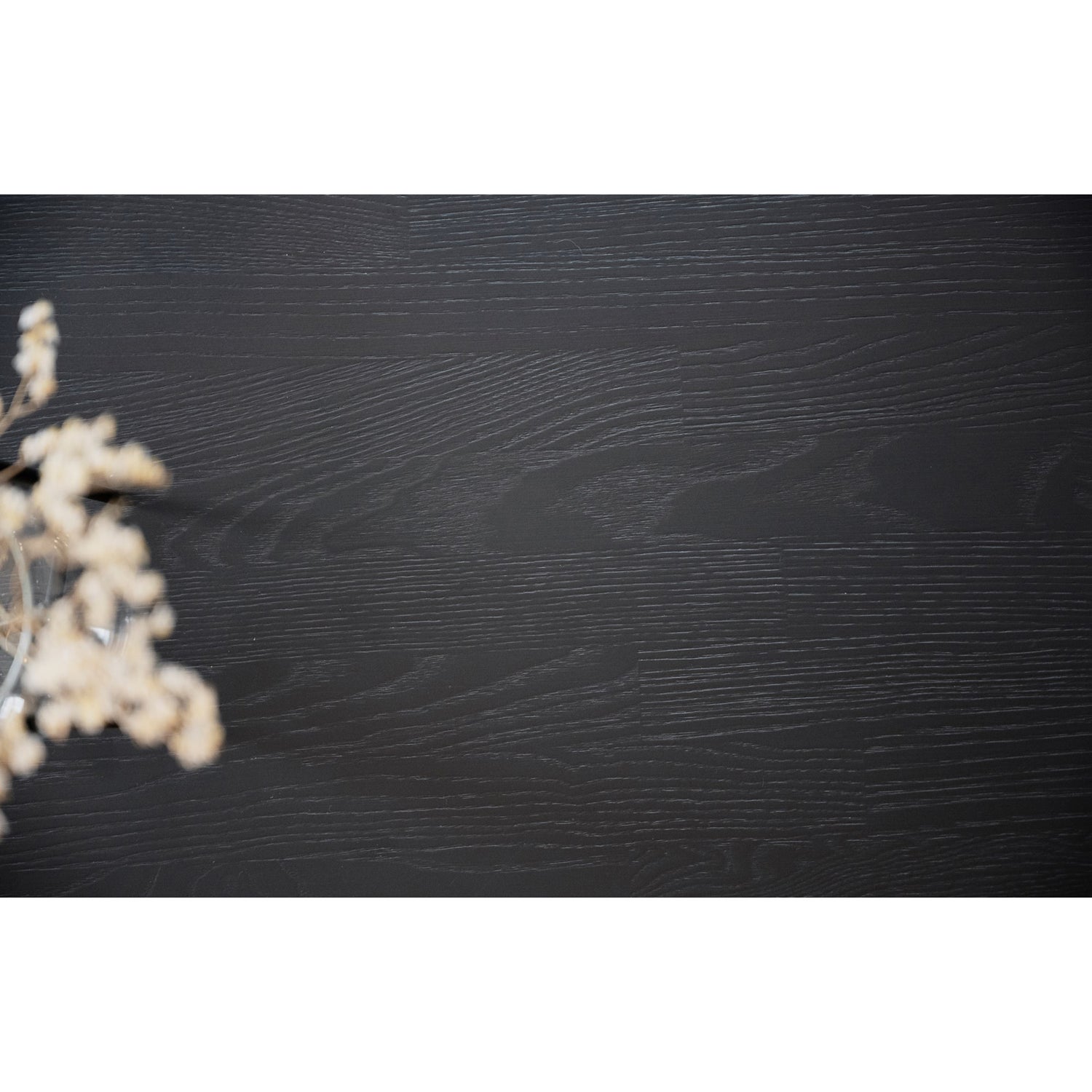 Lähikuvassa mustan pyöreän Fred-ruokapöydän saarnipuinen kansilevy.