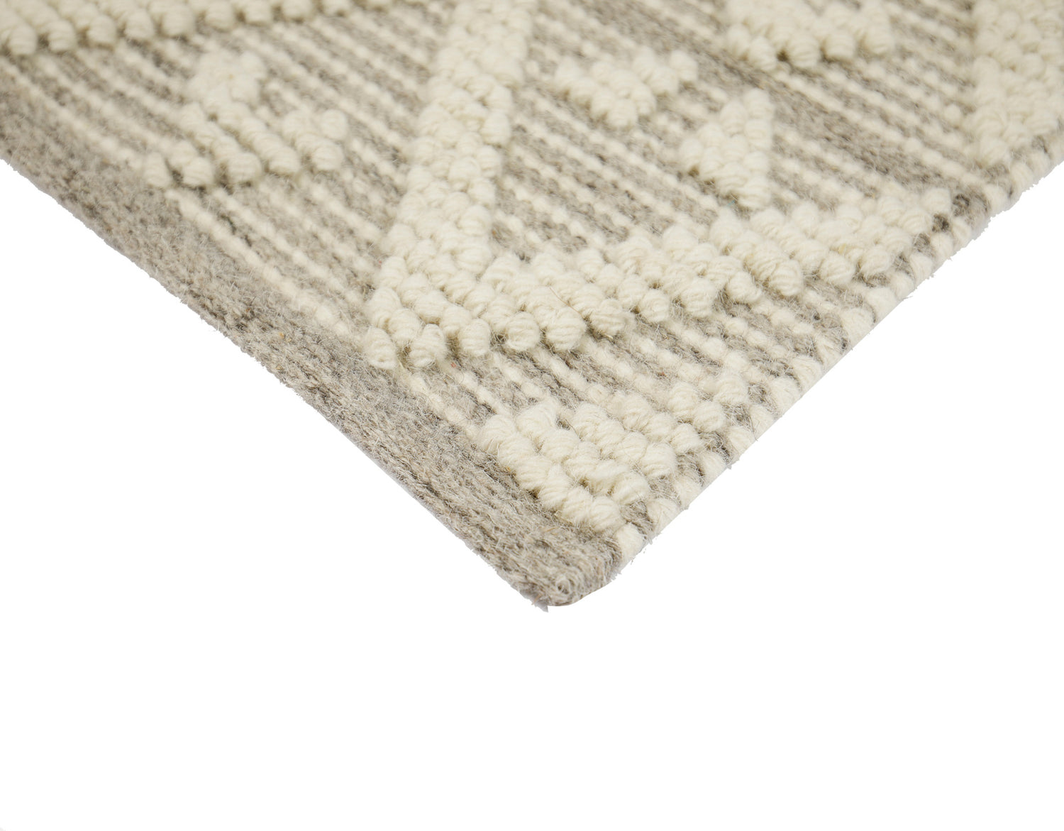 Lähikuvassa käsinkudotun Helmi-villamaton vaaleanharmaata kohokuvioitua villapintaa.