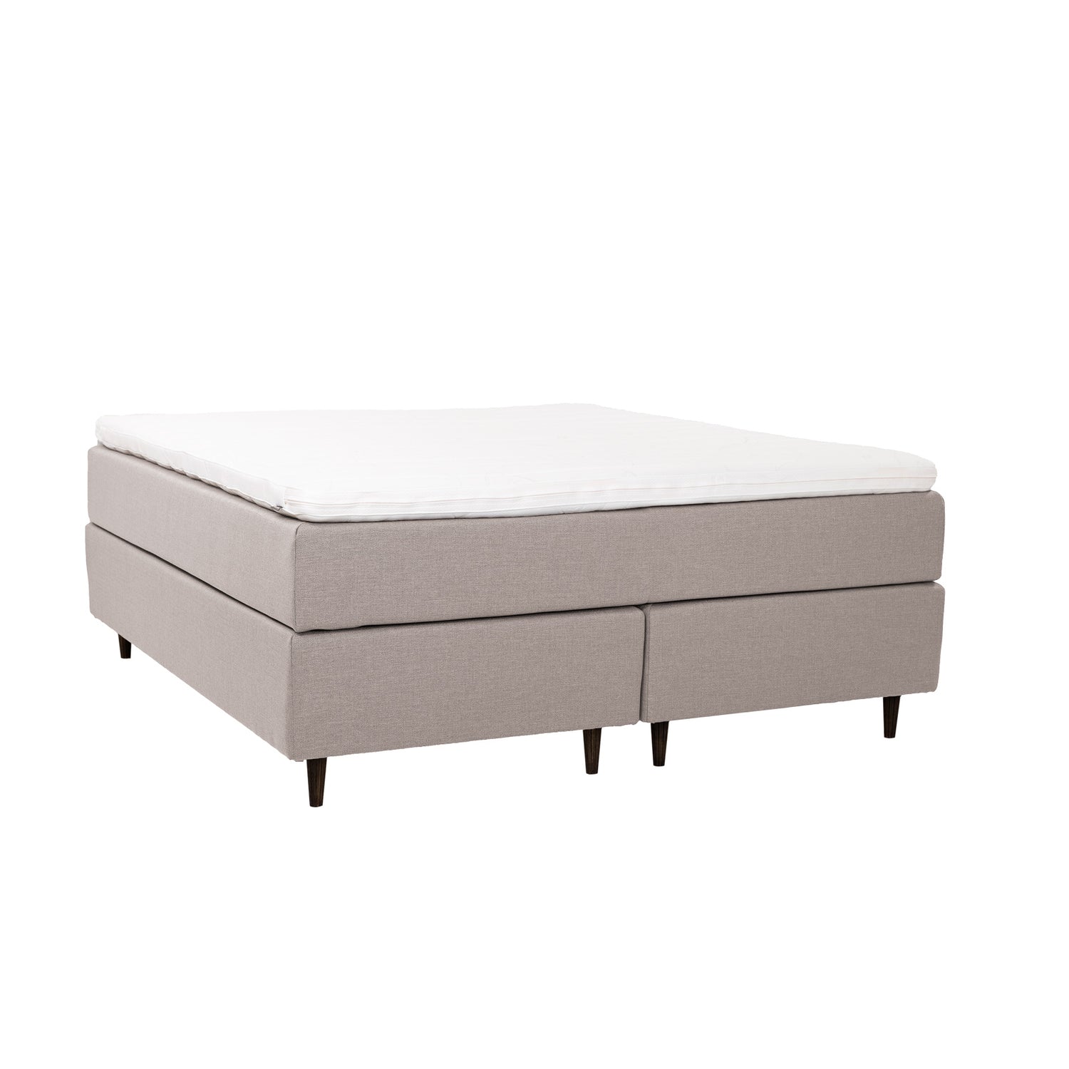 Beige Hilding Cross -jenkkisänky tummanruskeilla pyöreillä Hilding Raita -tammijaloilla ja yhtenäisellä Ergo -sijauspatjalla.