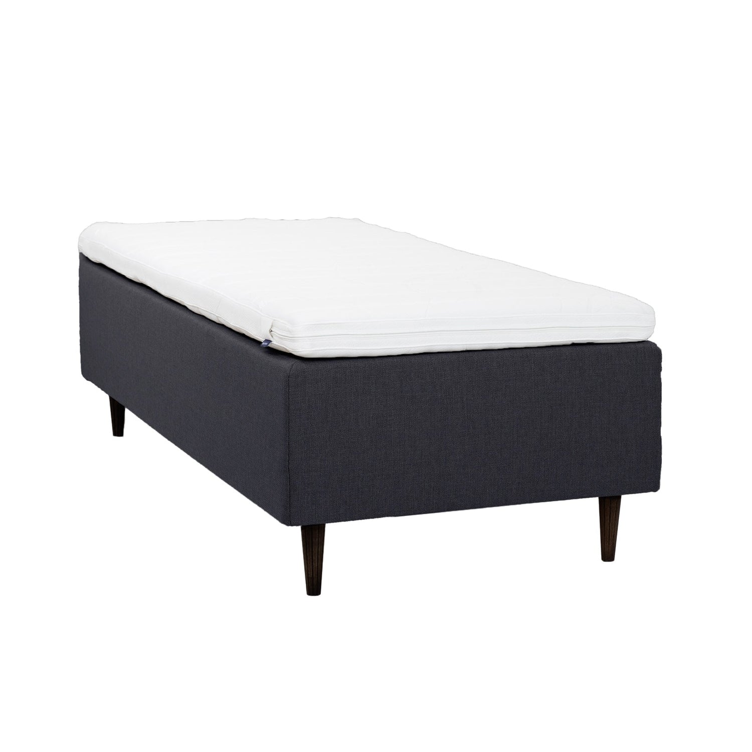 Antrasiitinvärinen Hilding Cross -runkopatja 80 x 200 cm tummanruskeilla 23 cm korkeilla pyöreillä Hilding Raita -tammijaloilla ja Hilding Ergo -sijauspatjalla.