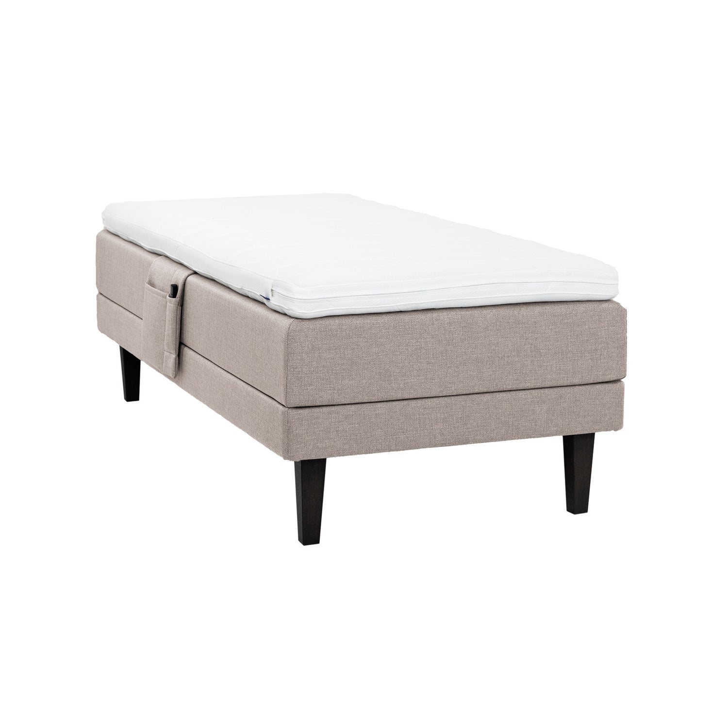 Beige Hilding Feel Ergo -moottorisänky 90 x 200 cm hiilenmustilla 23 cm korkeilla Royal -tammijaloilla ja Hilding Ergo -sijauspatjalla. Kuvan tarviketasku myydään erikseen.
