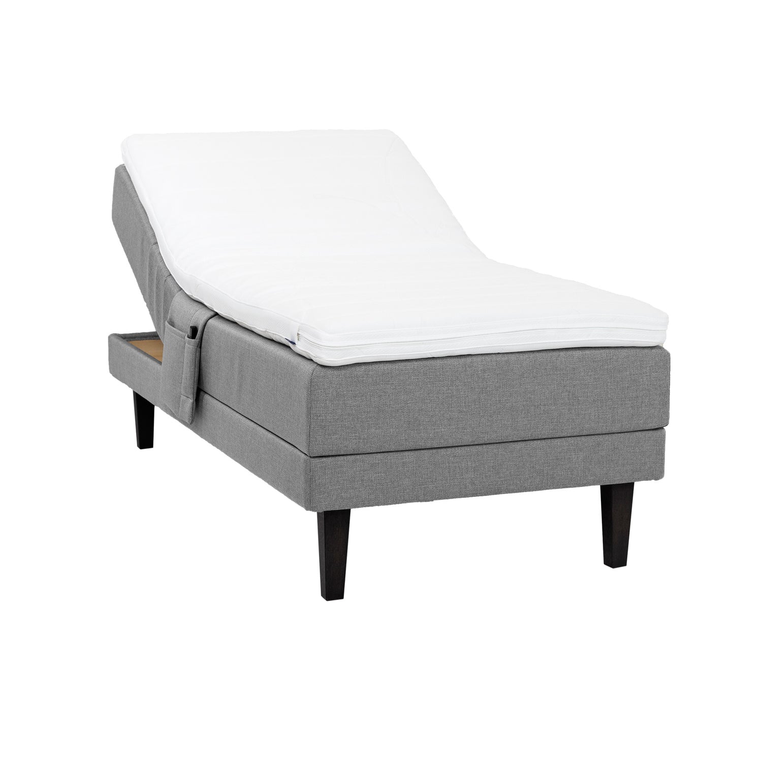 Harmaa Hilding Feel Ergo -moottorisänky 90 x 200 cm hiilenmustilla 23 cm korkeilla Royal -tammijaloilla ja Hilding Ergo -sijauspatjalla. Kuvan tarviketasku myydään erikseen.