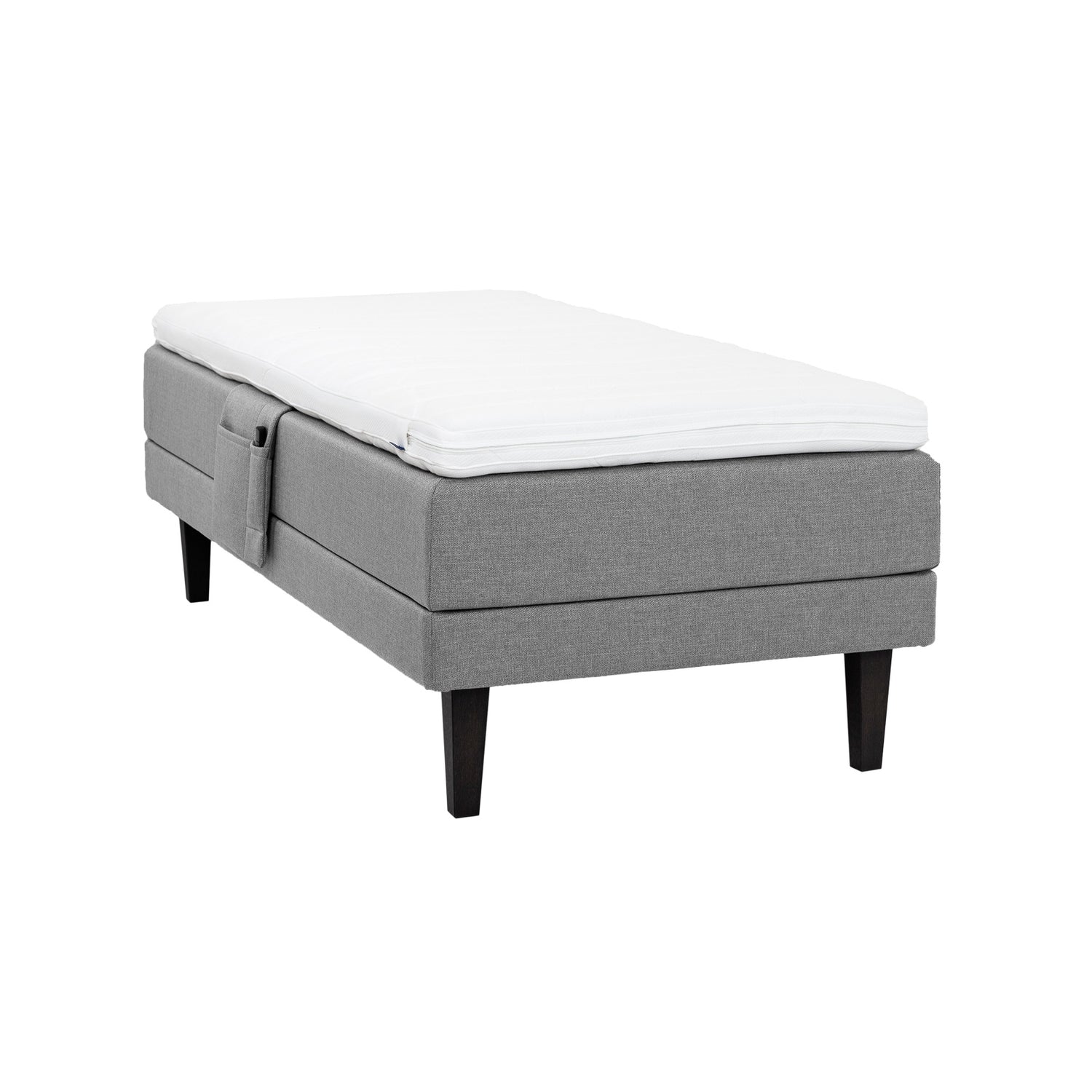 Harmaa Hilding Feel Ergo -moottorisänky 90 x 200 cm hiilenmustilla 23 cm korkeilla Royal -tammijaloilla ja Hilding Ergo -sijauspatjalla. Kuvan tarviketasku myydään erikseen.